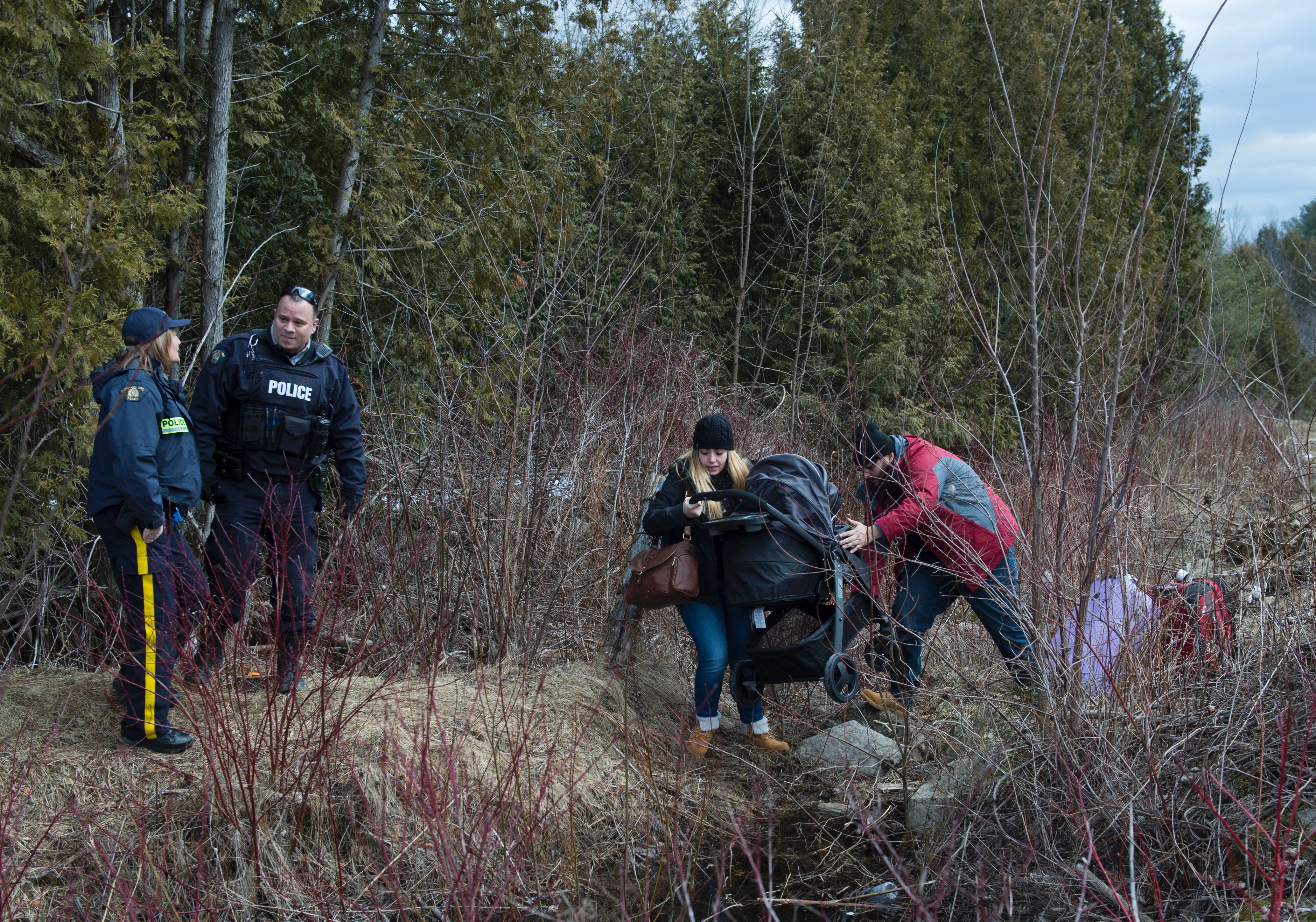 A couple who claimed to be from Turkey struggles to get their baby and baby carriage across the US/Canada border February 27, 2017, in Champlain, New York. 
                      There continues to be an increasing number of people crossing the US border into Canada illegally. (DON EMMERT—AFP/Getty Images)