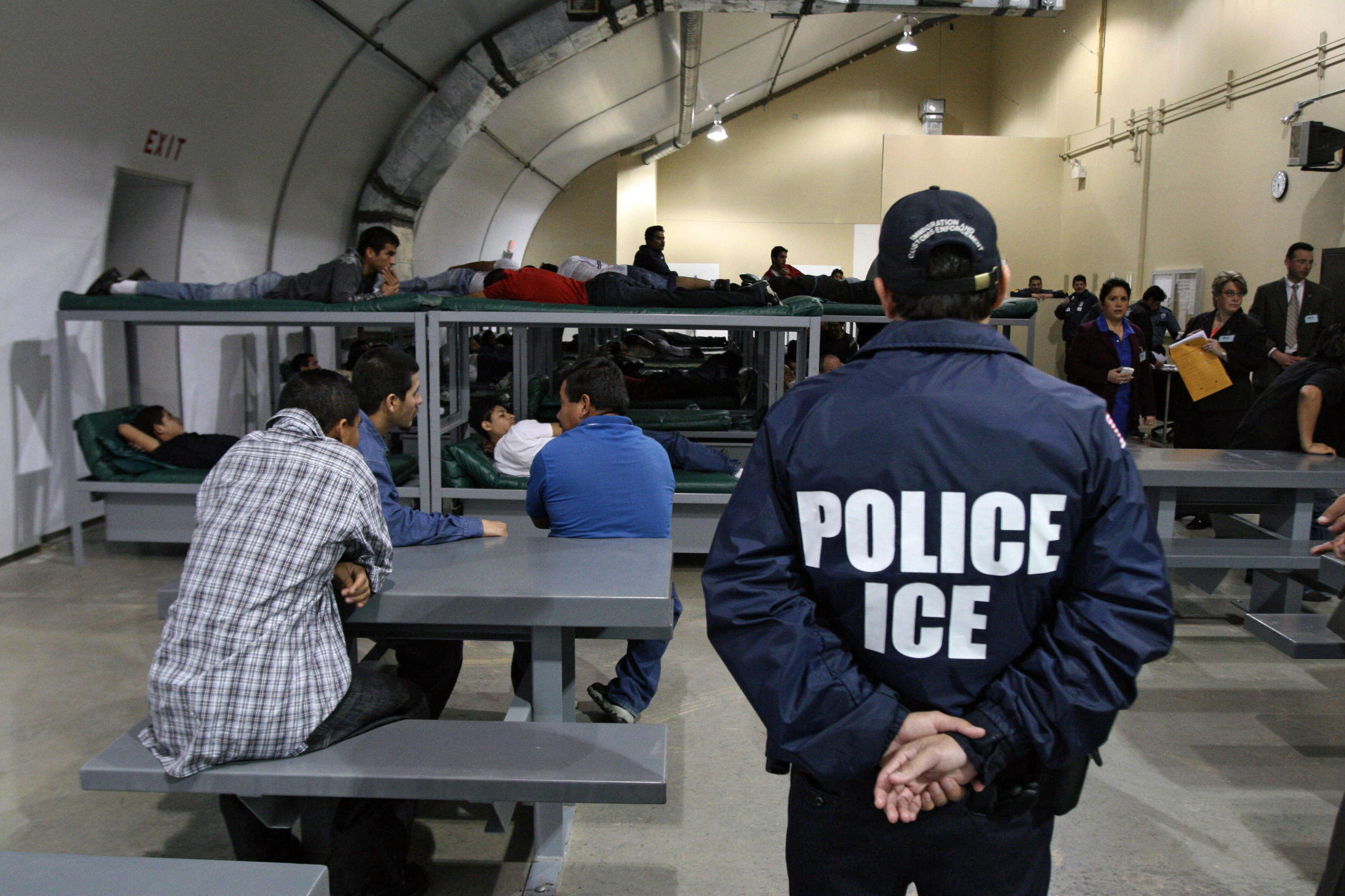 An Immigration and Customs Enforcement (ICE) officer guards a group of immigrations at a facility in Raymondsville, Texas, in 2008. (JOSE CABEZAS—AFP/Getty Images)