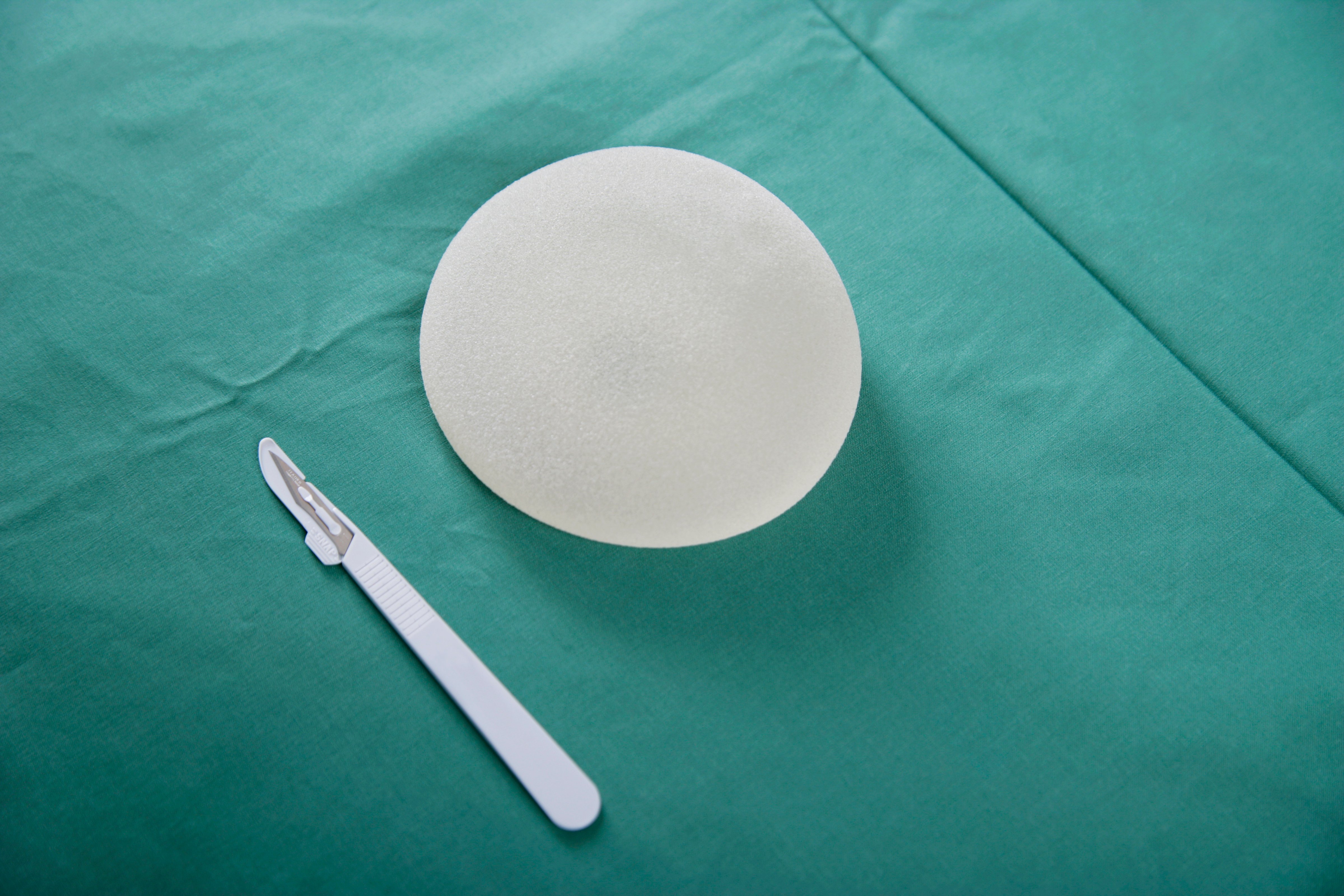 A breast implant and scalpel