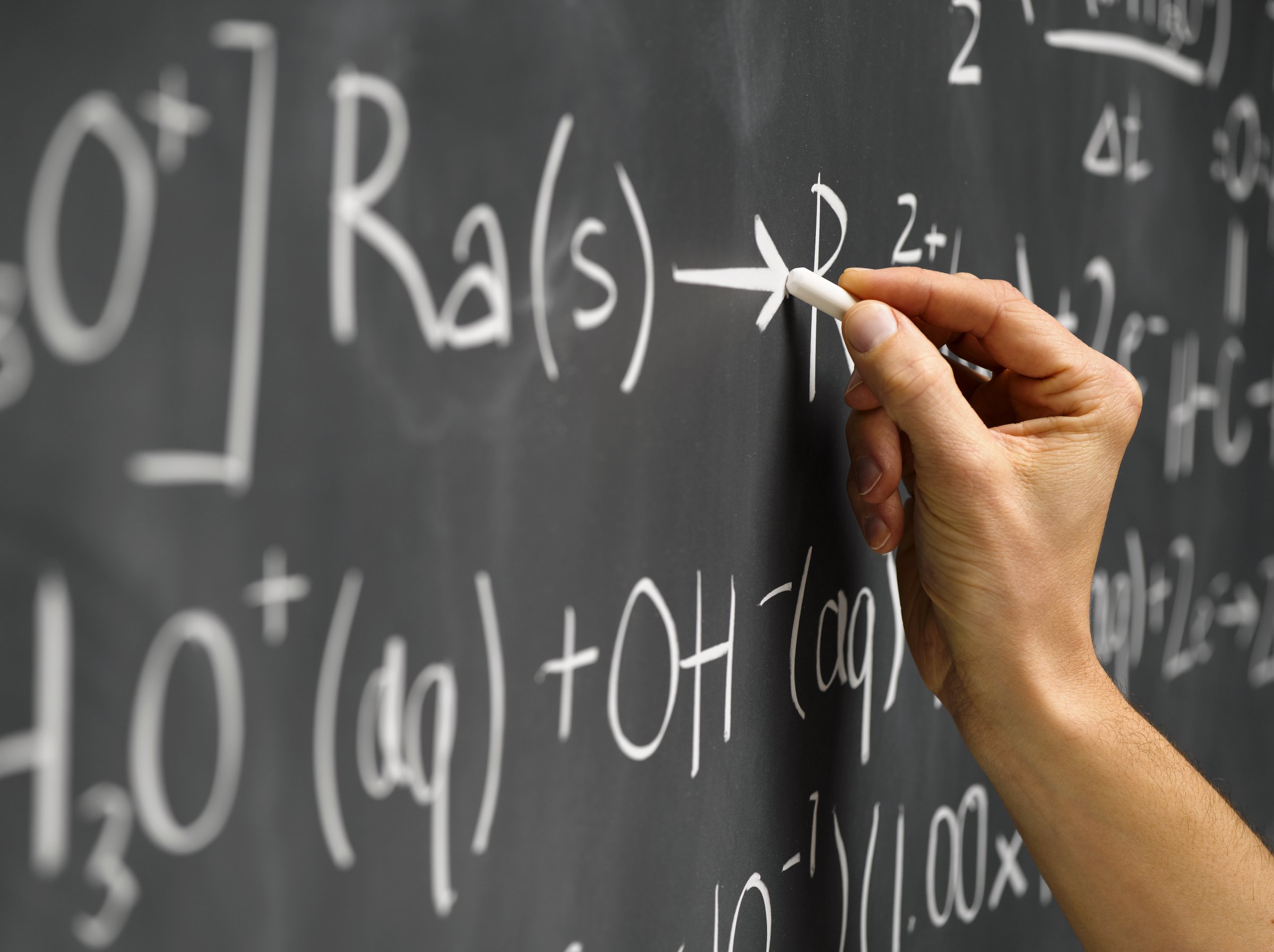 hand writing equation on blackboard