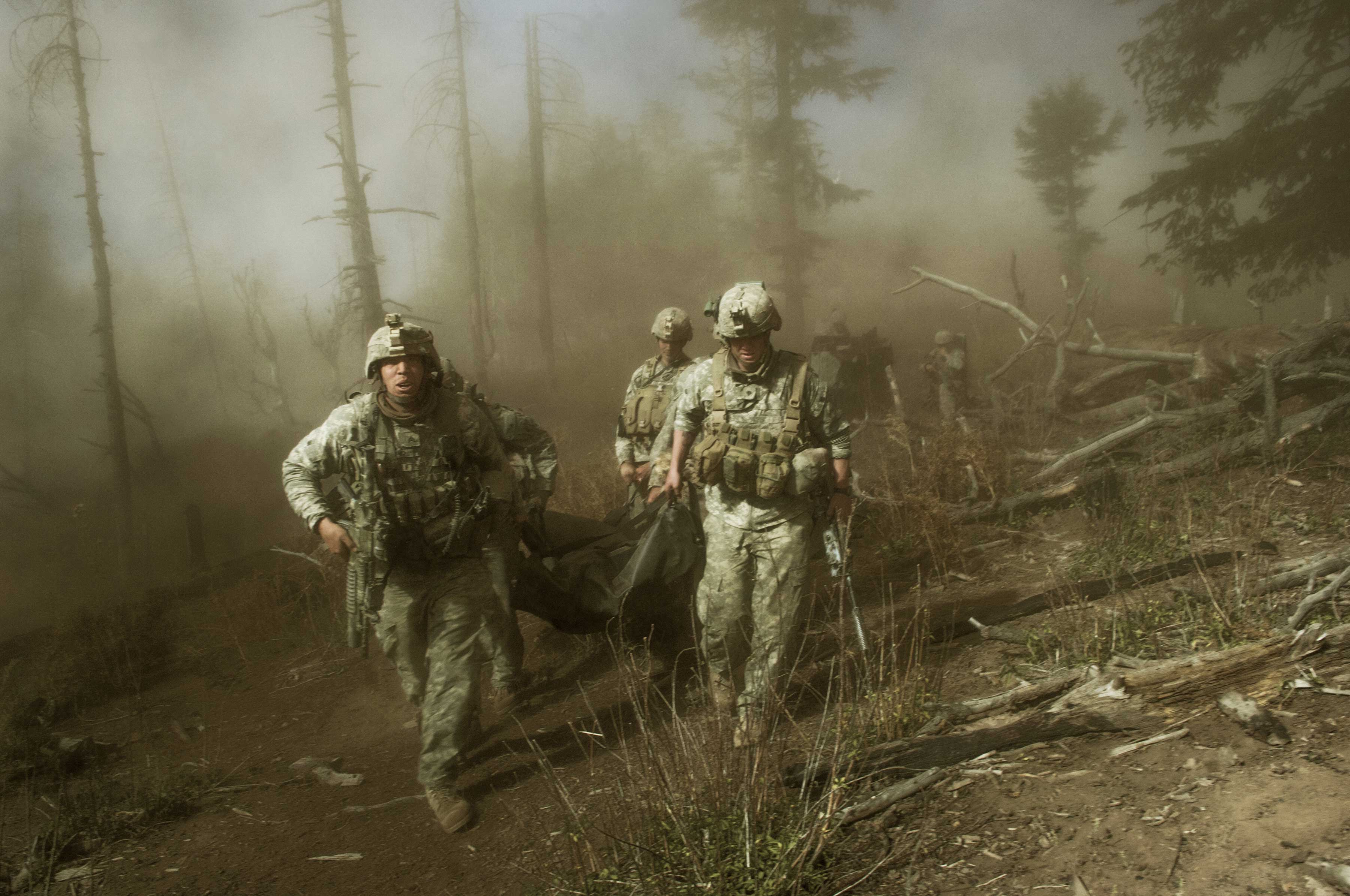 Soldiers with the 173rd Airborne, Battle Company, on a battalion-wide mission in the Korengal valley on the Abas Ghar ridge line. front left: Sgt. John Clinard, and right, Jay Liske, and other soldiers from Battle Company, carry the body of Sgt Larry Rougle, of Utah on Oct. 23, 2007. (Lynsey Addario)
