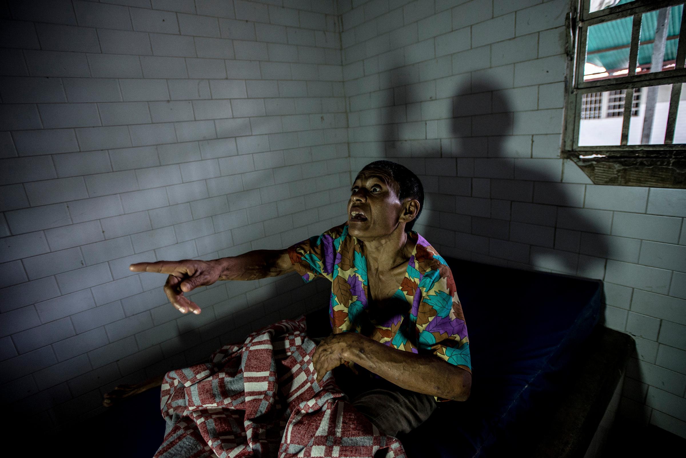 Margarita Silva, a paranoid schizophrenic, yells at nurses from her solitary confinement cell, where she was being held after biting off another patient's nose and eating it, at the state-run Pampero Psychiatric Hospital in Barquisimeto, Venezuela, on Aug. 24, 2016.