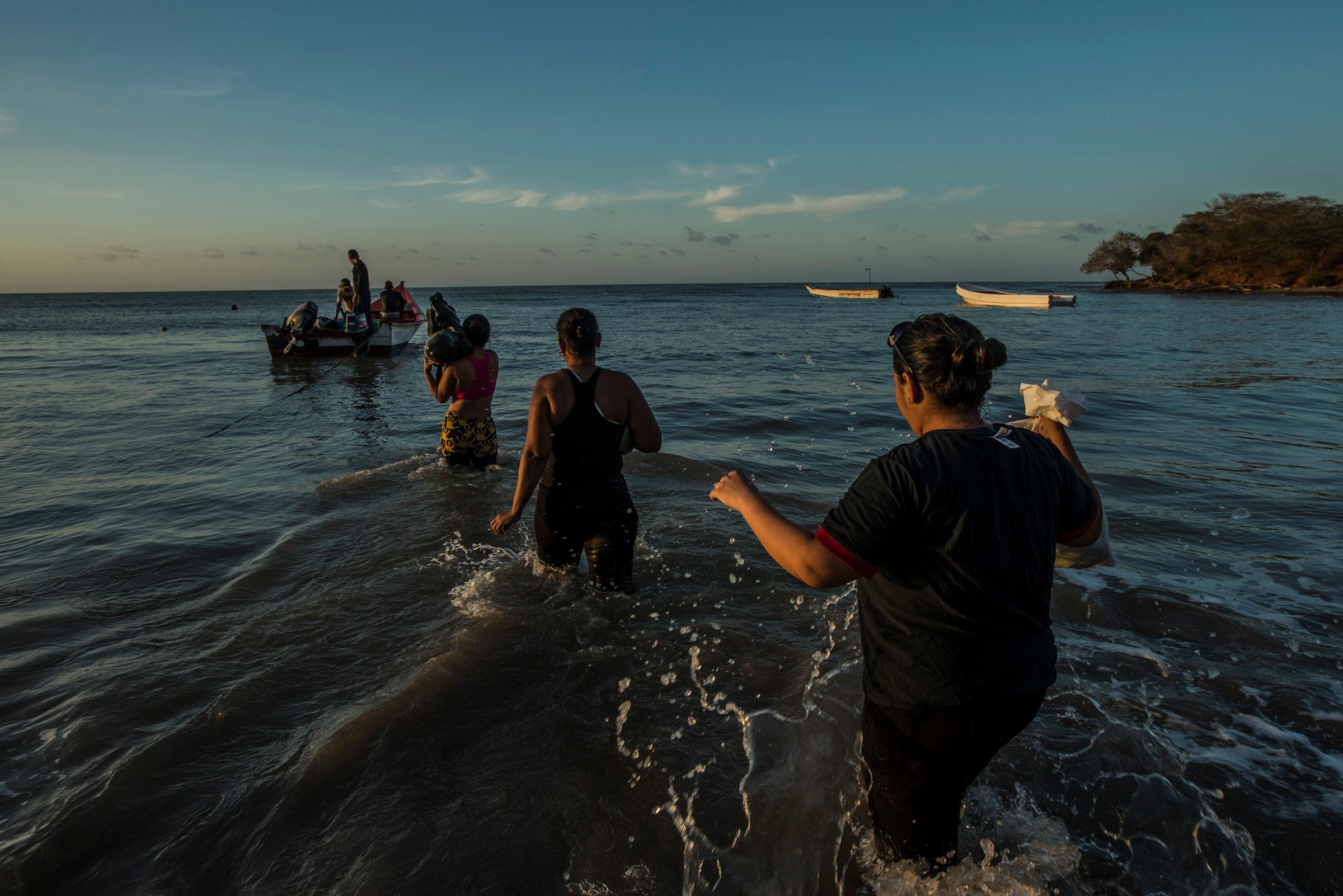 Migrants board a smuggler's boat that will take them to the Caribbean island of Curacao on Sept. 26, 2016. More than 150,000 people have fled the economic collapse in Venezuela in the last year alone, the most in more than a decade, scholars say, with the sea route posing special dangers.