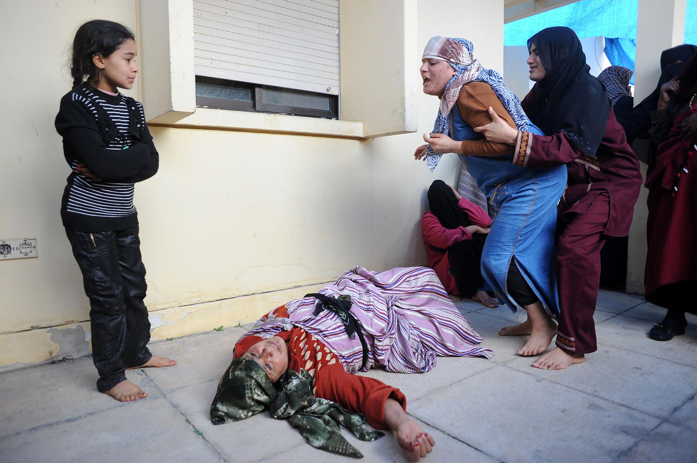 Mobarak Mohamed, 46, lies distraught on hearing the news that her son Hassan Ali, 14 had been killed by Gaddafi's forces during the first Battle of Brega, March 2 2011. Libya.