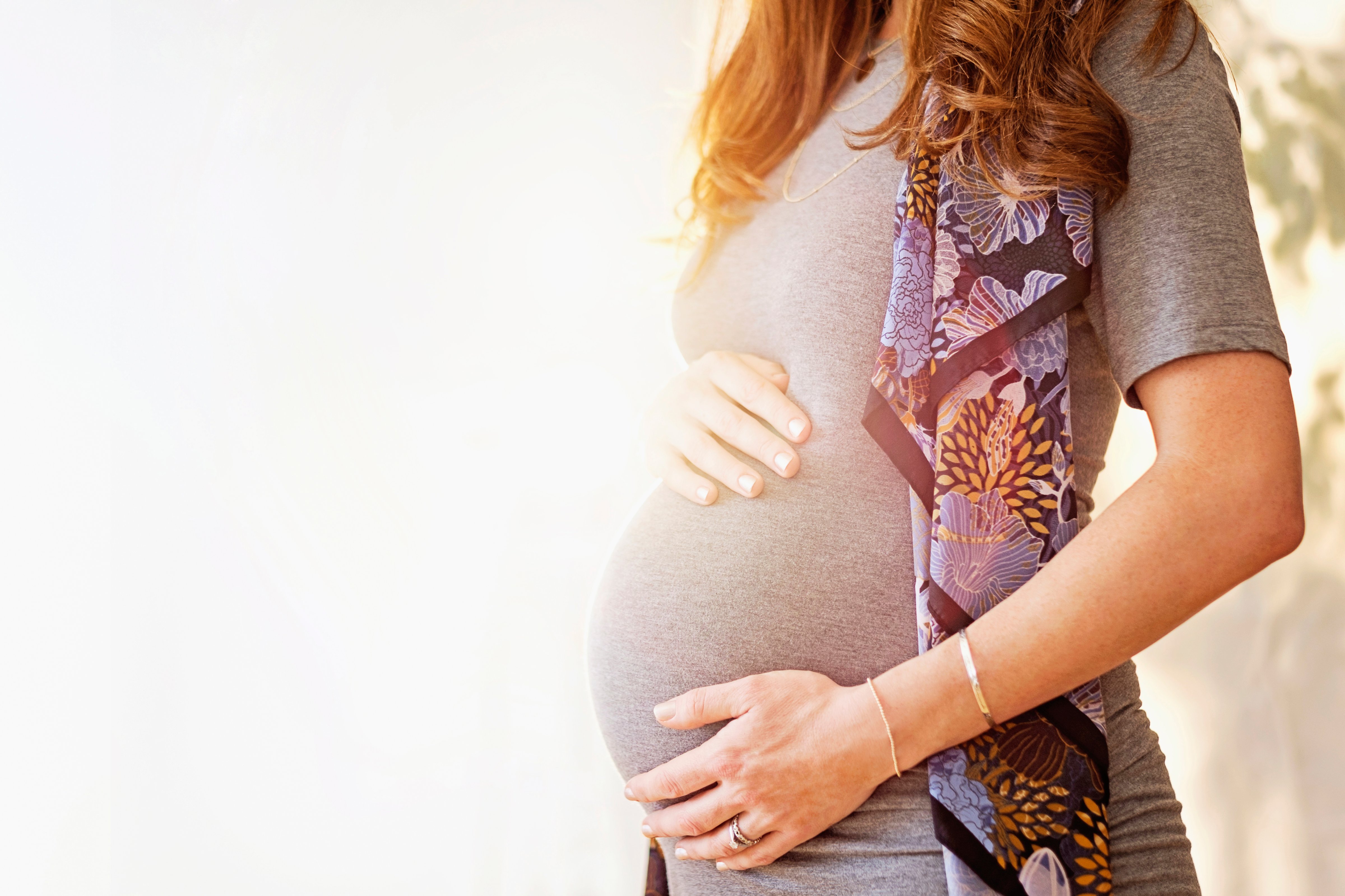 Mid-section of pregnant woman outdoors