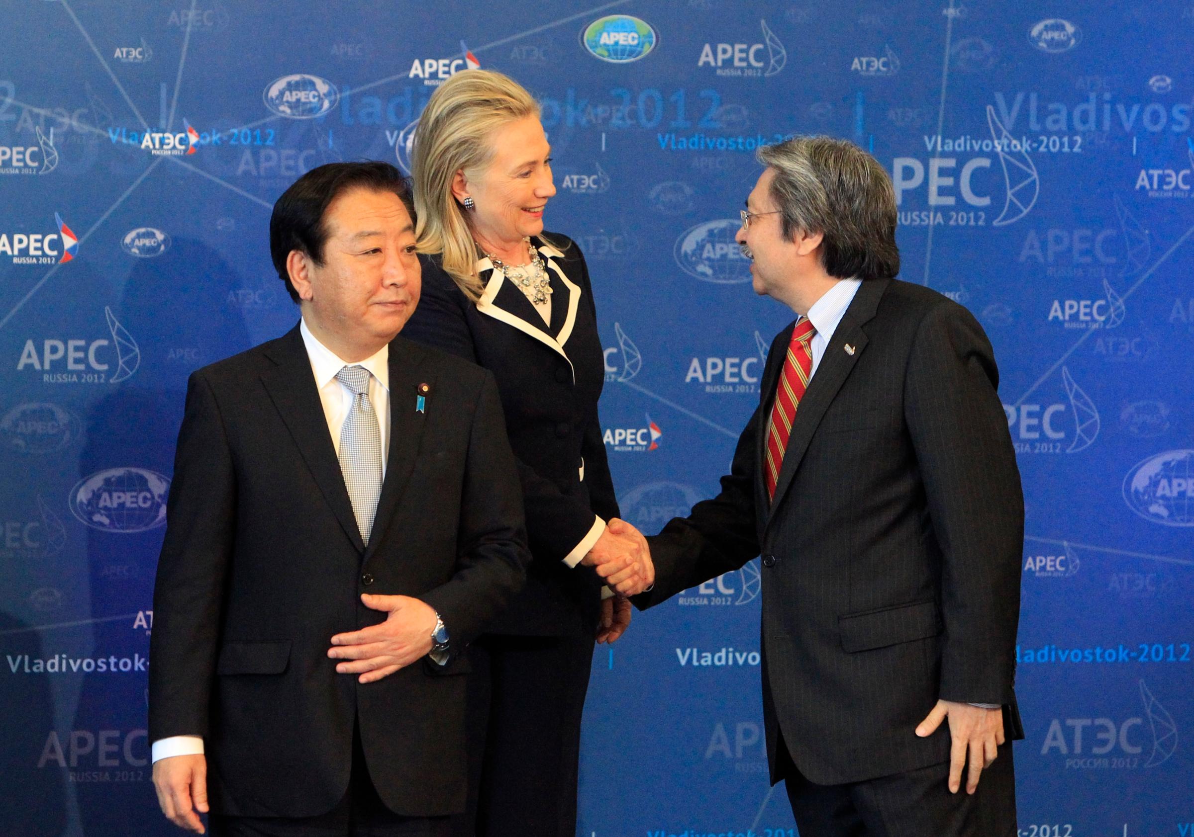 U.S. Secretary of State Hillary Clinton shakes hands with Hong Kong's Financial Secretary John Tsang during a group photo in Vladivostok