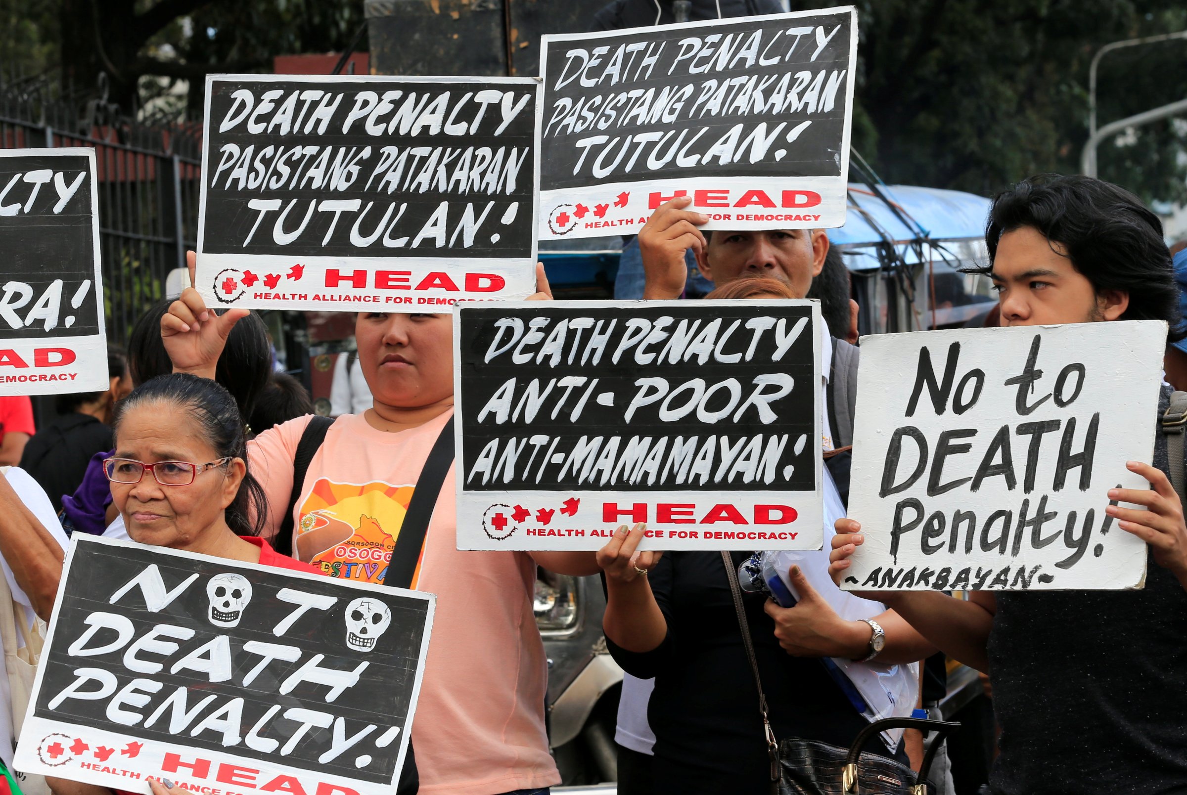 Activists holds placards during a protest rally against the passing of the death penalty bill, at the gate of House of the Representatives in Quezon city