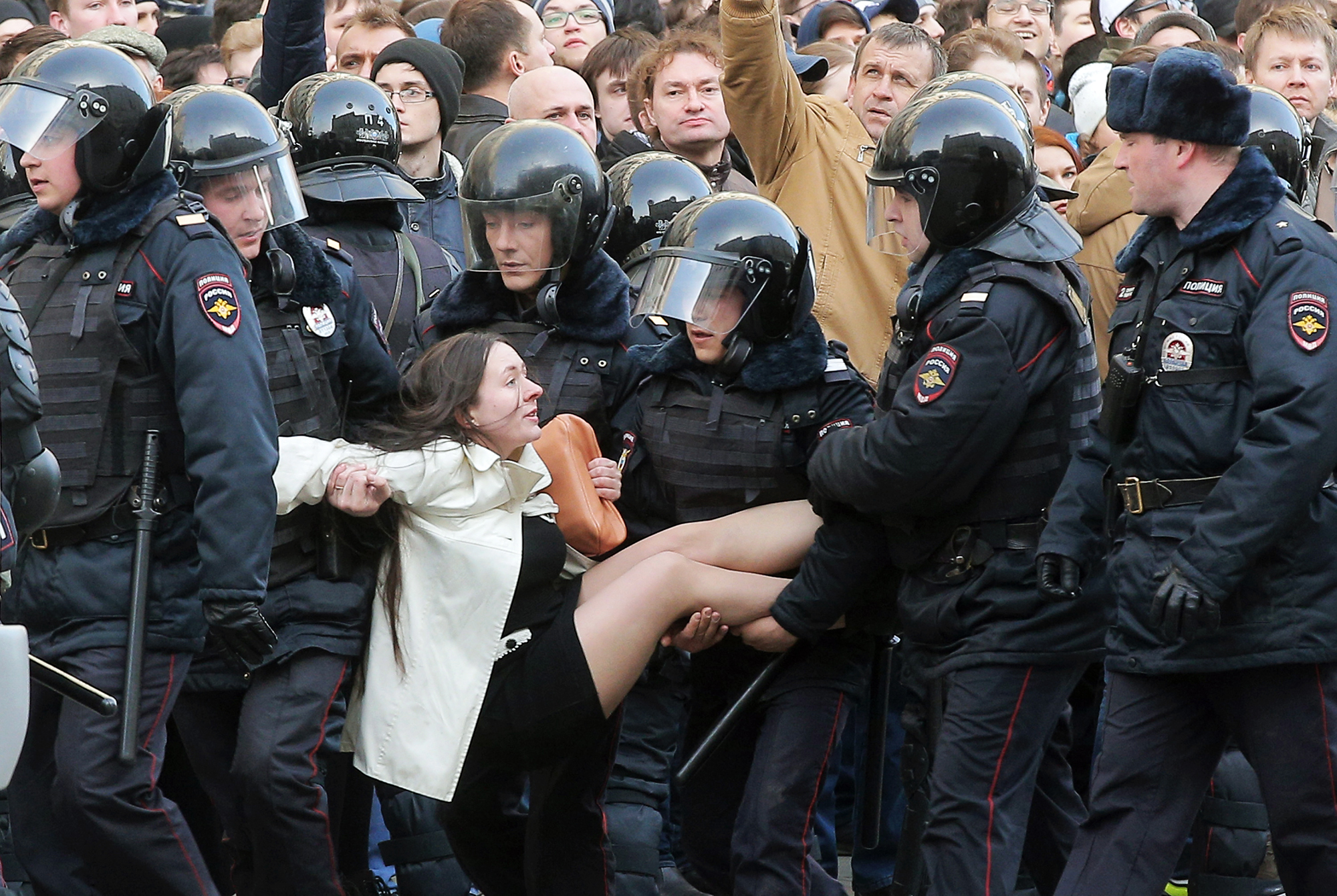 Police officers detain a demonstrator during an opposition rally in Moscow on March 26, 2017.