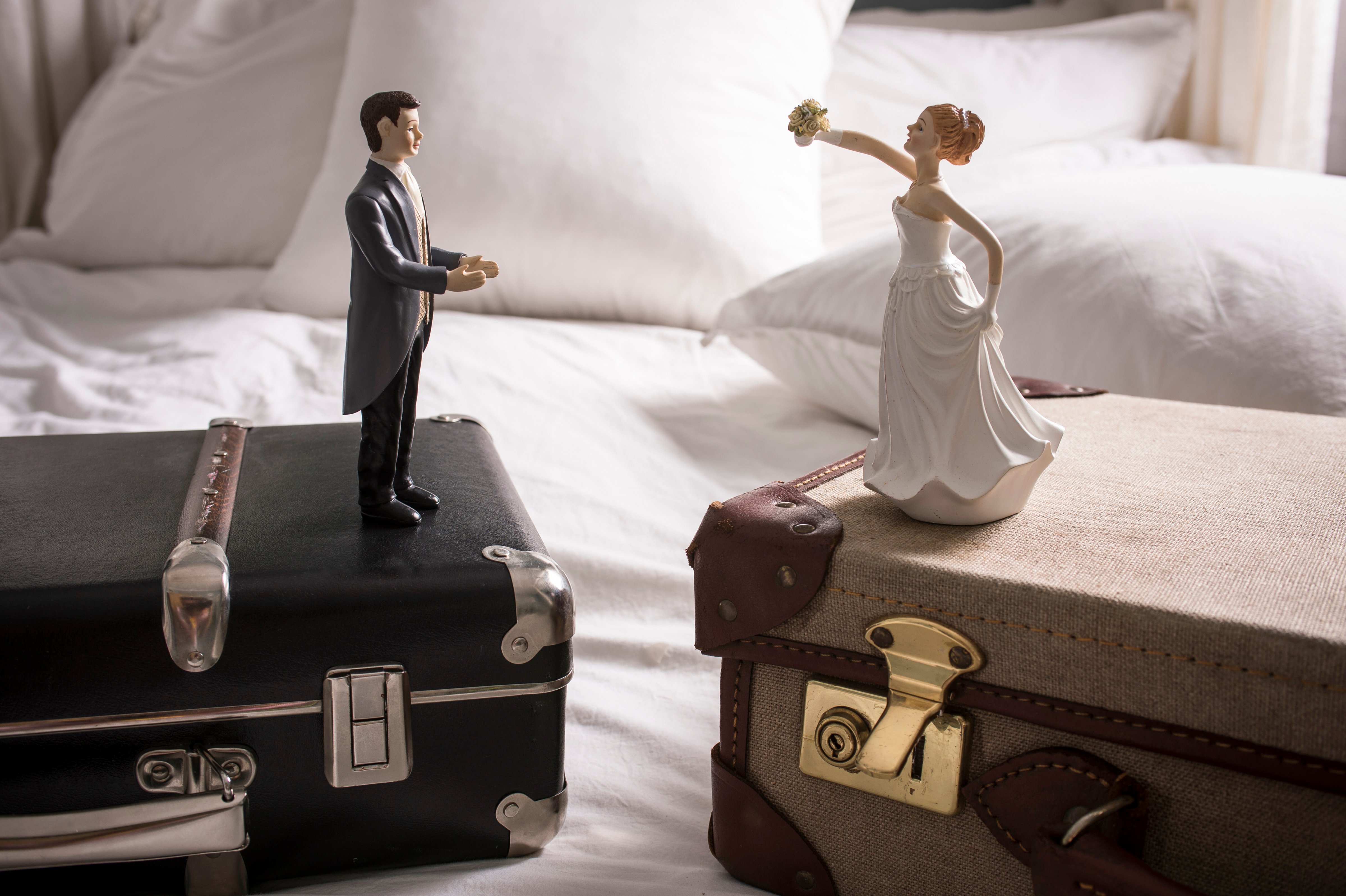 Wedding figurines on separate suitcases (Getty Images)