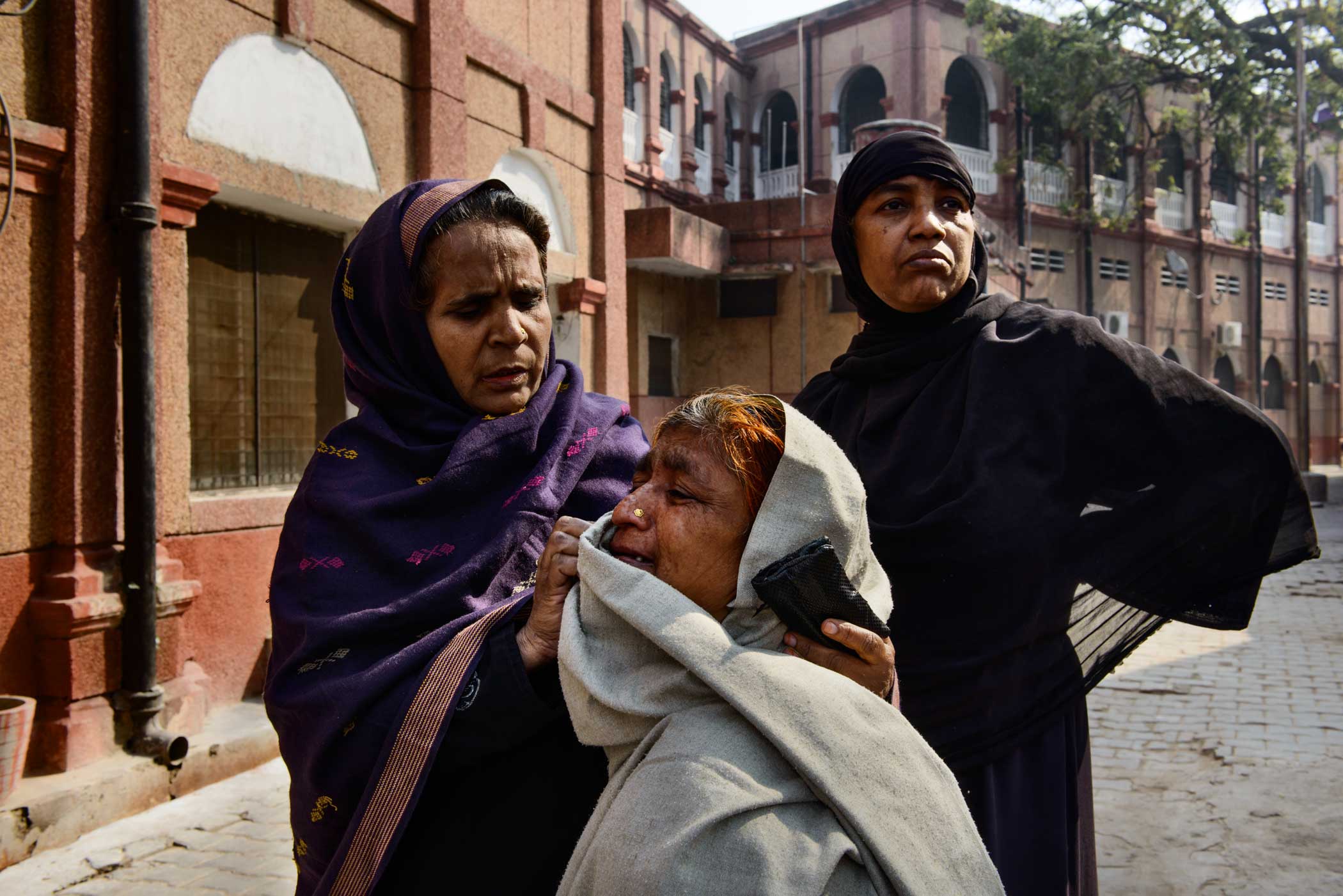 Relatives console Ruksana Bibi outside the Burn Ward of the Kabir Chaura hospital in Varanasi. Ruksana’s daughter Shama, 20, was attacked by three men who tried to rape her when she had gone out to fetch water. Shama resisted and the men were unable to rape her. They doused her in kerosene and lit her on fire. Shama died a week later. (Smita Sharma)