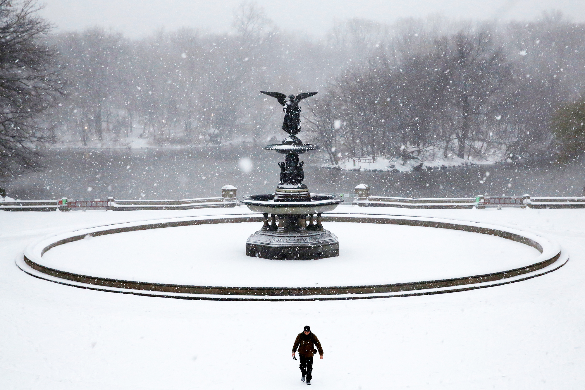 A man walks in Central Park as snow falls in New York City, on March 14, 2017.