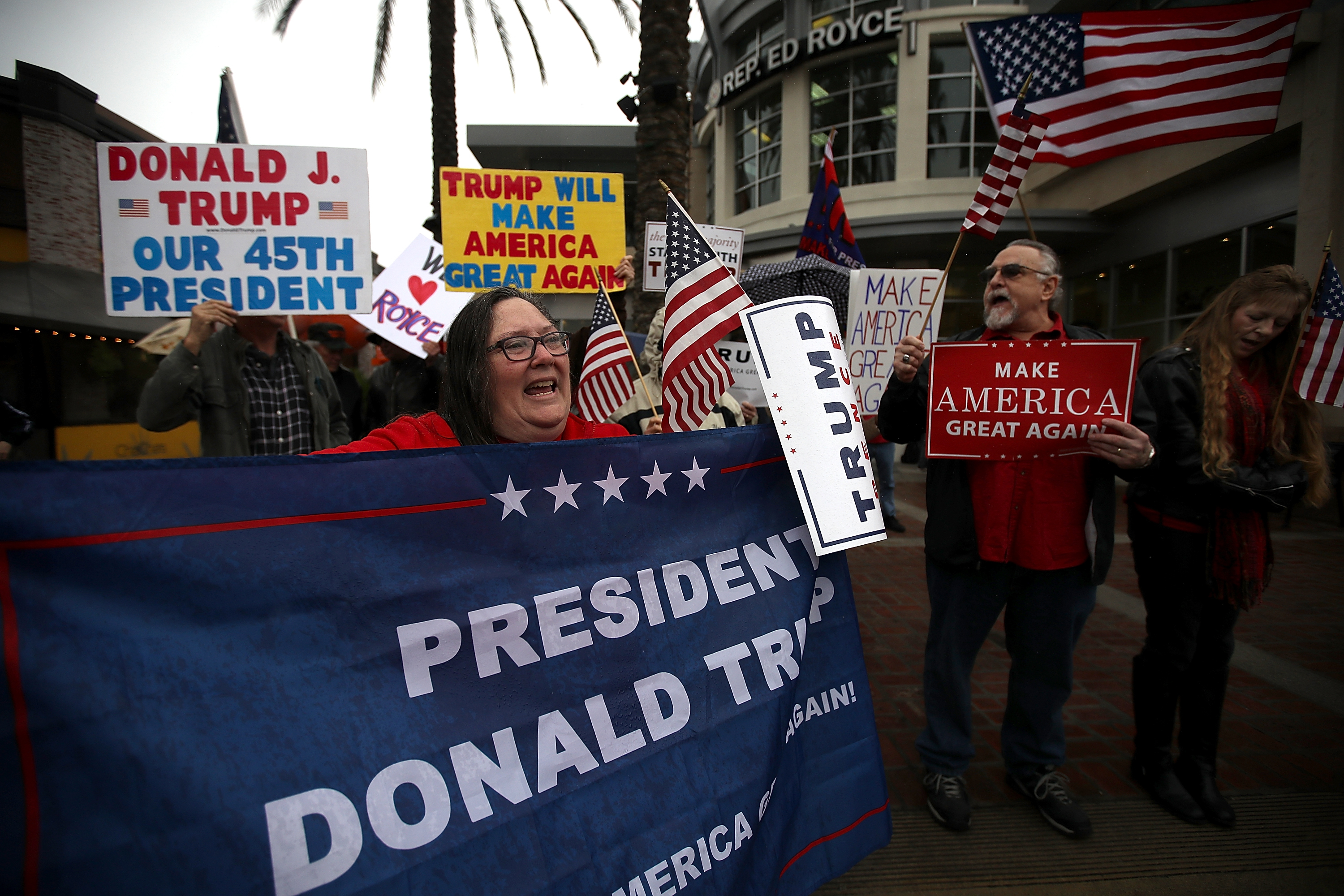 Supporters of U.S. President Donald Trump hold signs during a rally in favor of the "America First" agenda on February 27, 2017 in Brea, California. (Justin Sullivan—Getty Images)