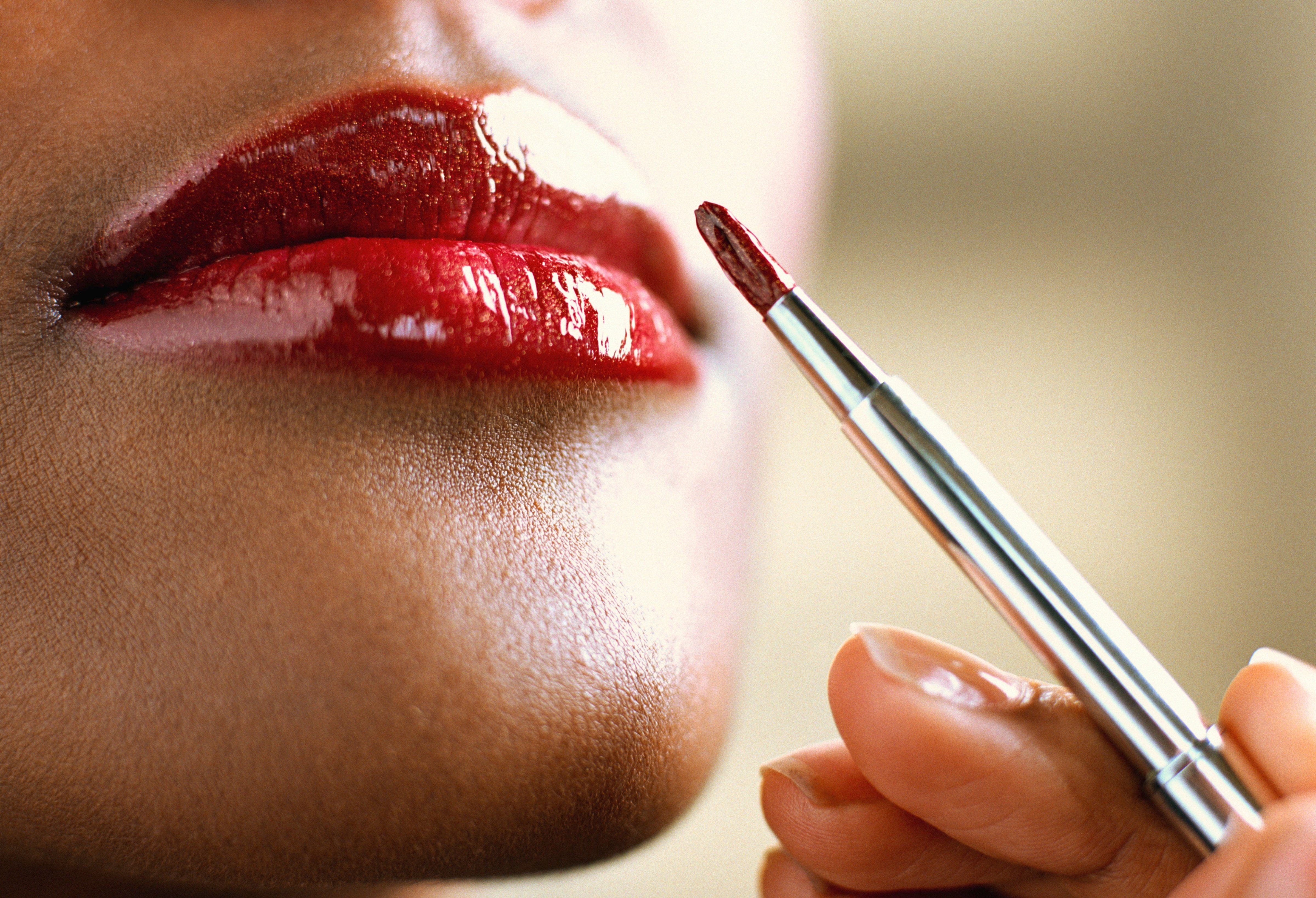 Woman applying lipstick with brush, close-up (John Slater&mdash;Getty Images)