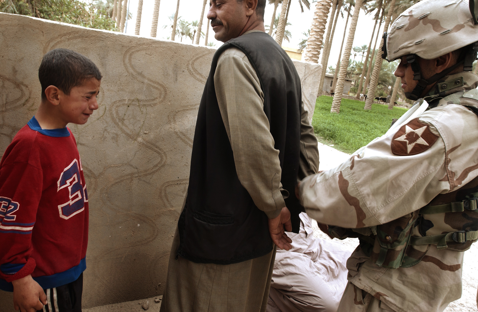 During a house to house search for insurgents in Ramadi, a boy cries as his father is taken away by U.S. soldiers, March 07, 2005.