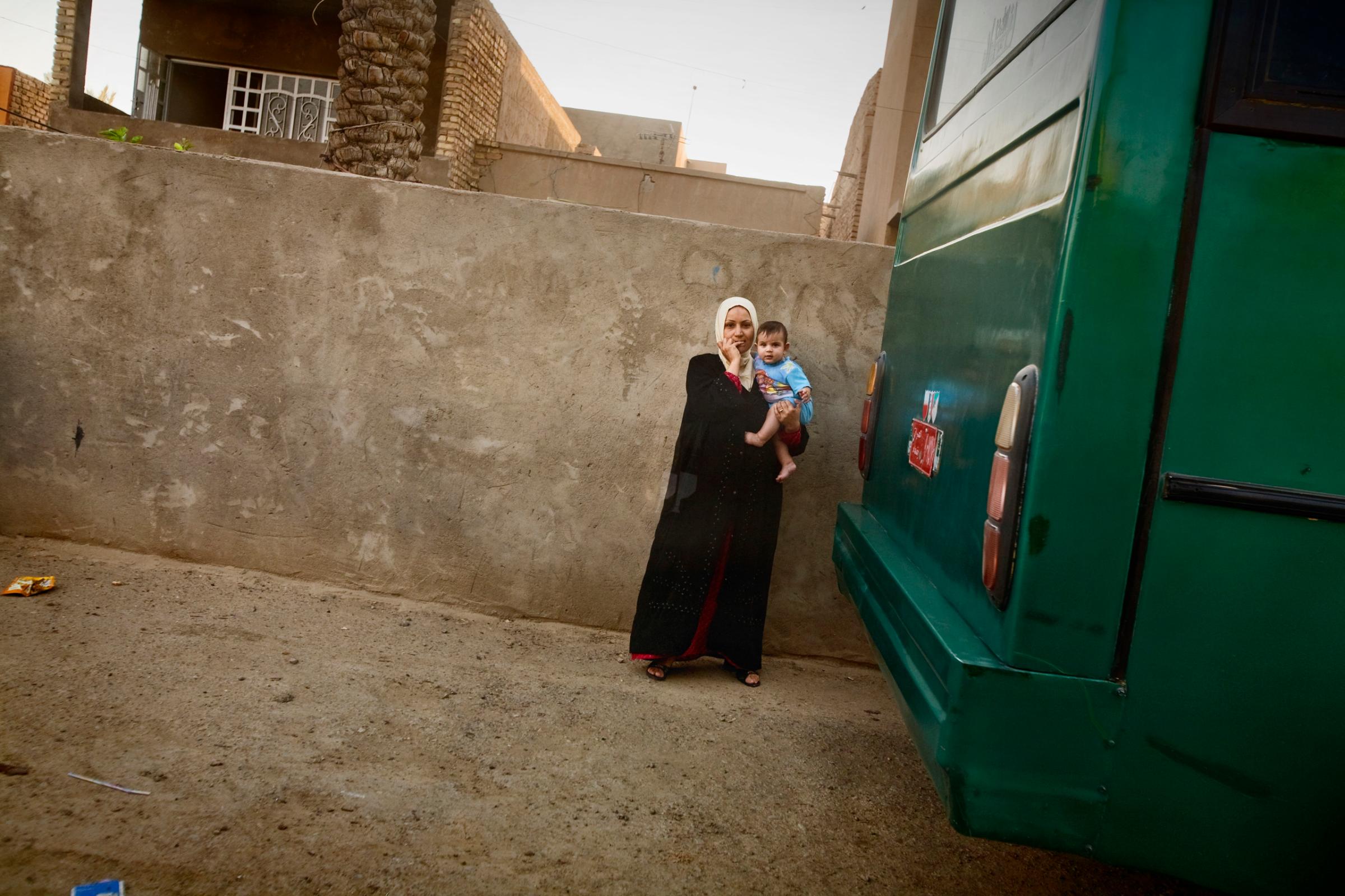 A woman holds her child outside her home in the al Doura district of Baghdad, Iraq, June 5, 2007. As sectarian tensions increased, life in Doura became increasingly dangerous when Iraqi National Policemen, former members of the pro-Shiite Badr Brigades, set up a check point outside the neighborhood and began shooting Sunni civilians, including women and children.