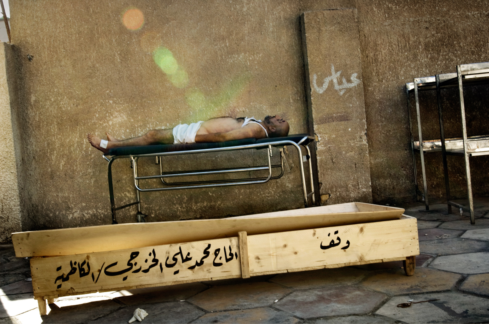 A body rests on a gurney at the Yarmouk hospital morgue in Baghdad, Iraq on July 26, 2006. People make a pilgrimage here every day in search of lost relatives that have disappeared during the night. In the previous night, 19 bodies were found in different neighborhoods throughout the city as a result of the sectarian bloodshed that is plaguing the country.