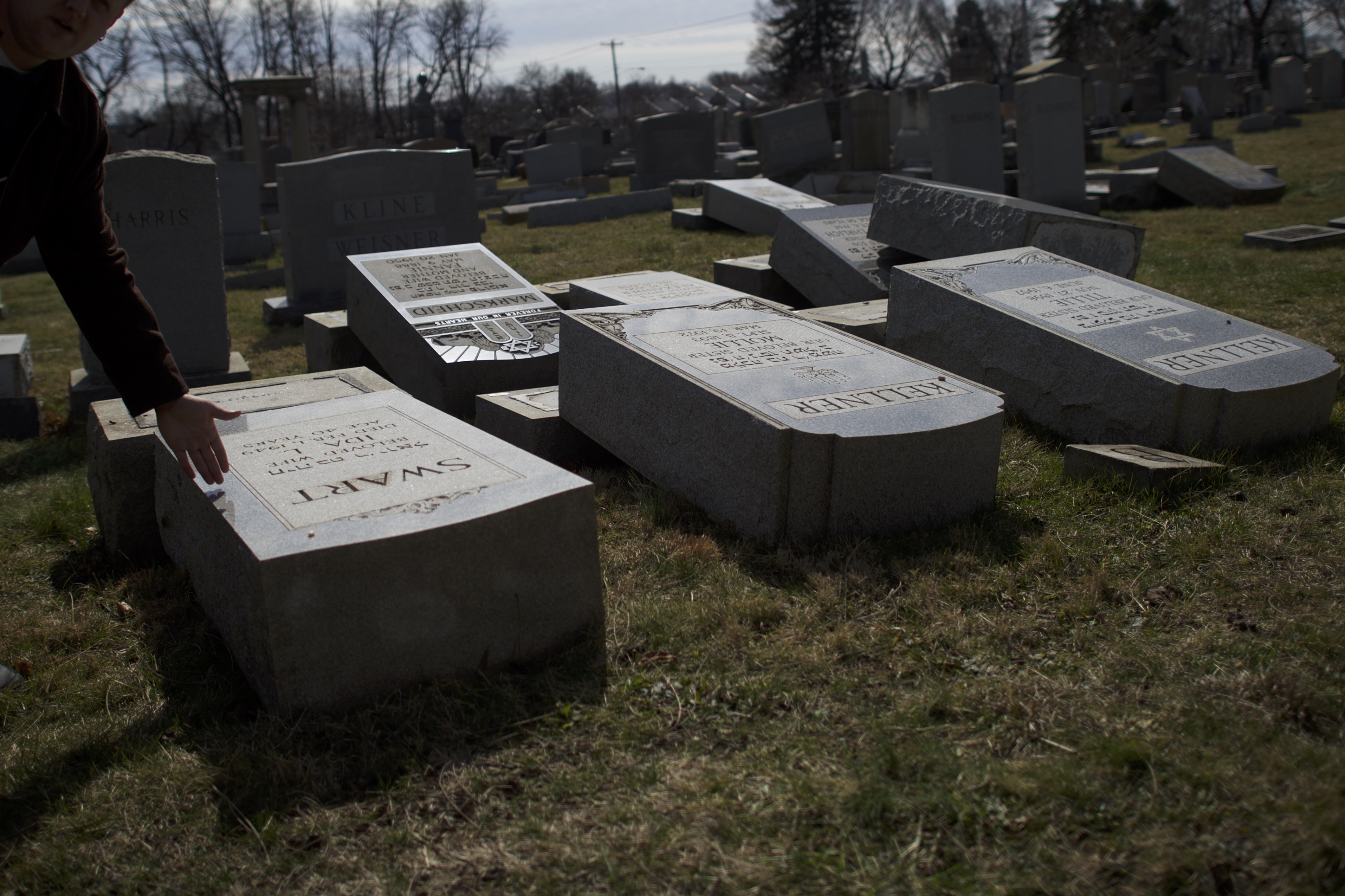A man motions towards Jewish tombstones vandalized at Mount Carmel Cemetery February 27, 2017 in Philadelphia, (Mark Makela—Getty Images)