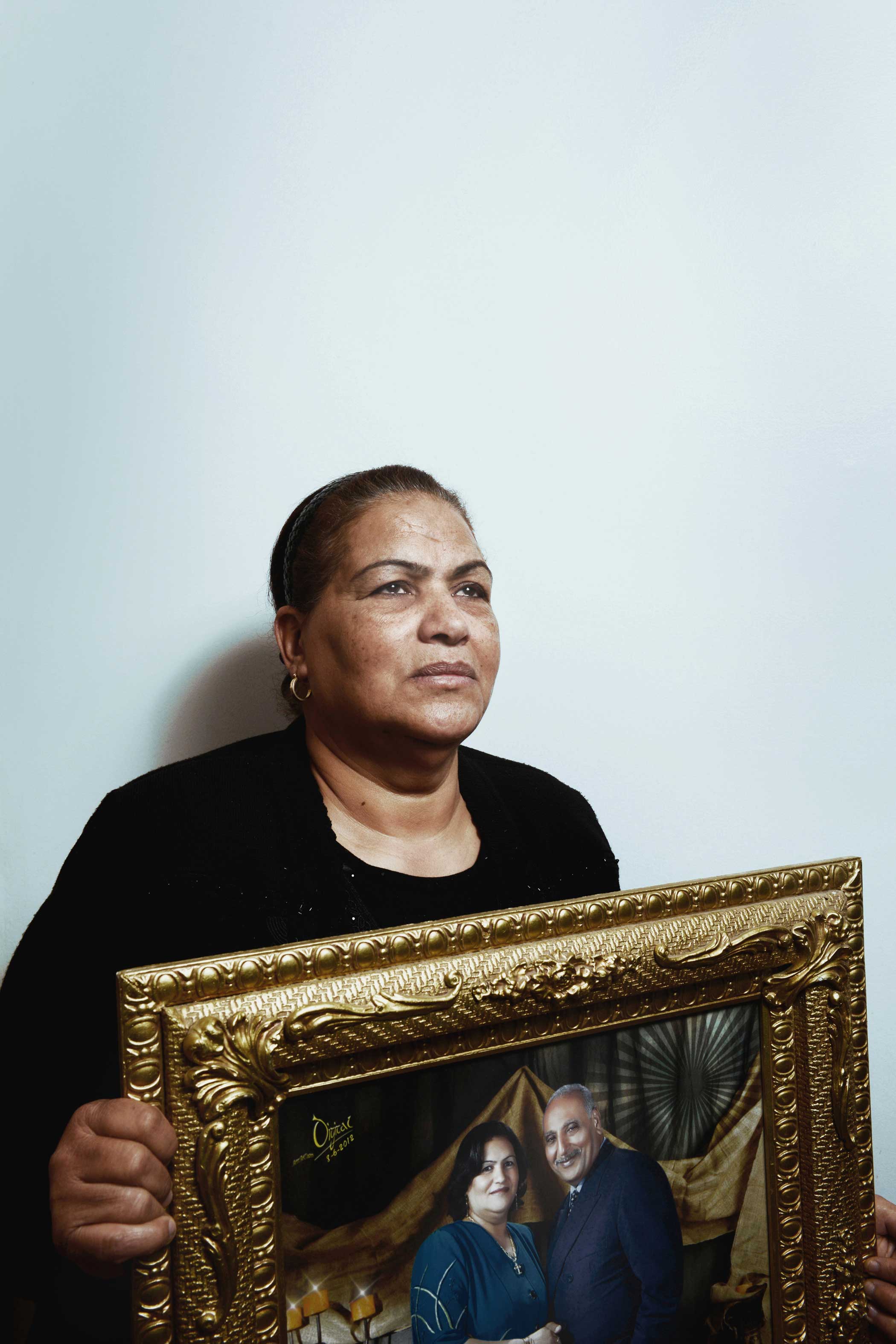 Enayat Shenouda, 62, holds a photo of her slain husband, Saad Zaki Badawi, 73. "Four months ago, after the recent Cairo Cathedral bombing, Saad told me he has wished he was one of the martyrs," Enayat said. "His wish came true yesterday. Now he is a martyr."