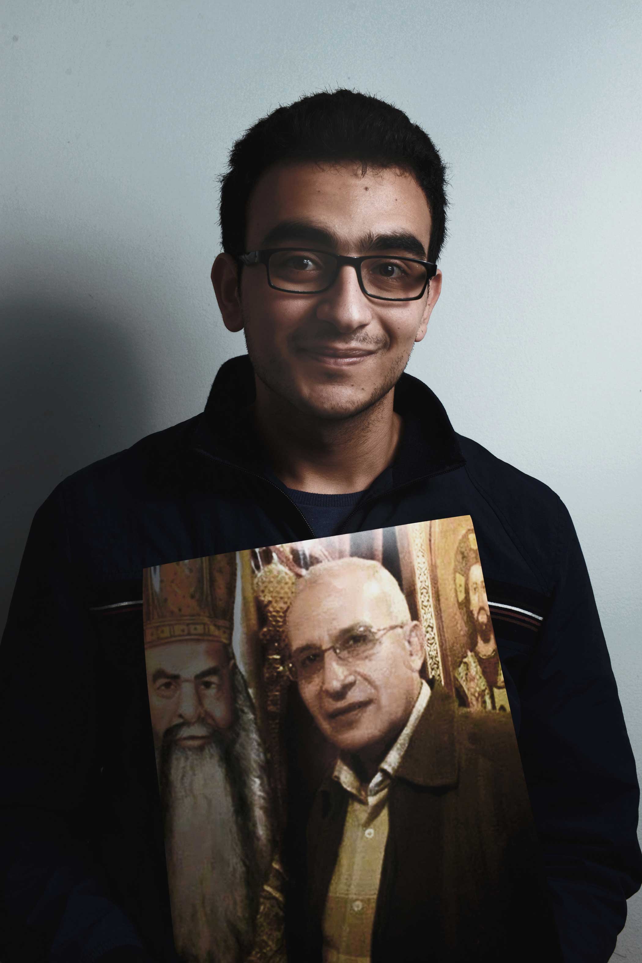 Abanoub, 22, holds a photos of his slain father, Michael Al-Almalek Mansour, 60.  I was watching the Palm Sunday service on TV and I saw the footage being cut off—hearing the screams of people. Once I saw that, I realized that my dad was dead. He always sat on the front bench during services,  Abanoub said.  My dad slept next to me on bed the night before Palm Sunday. That was the last time I saw him.