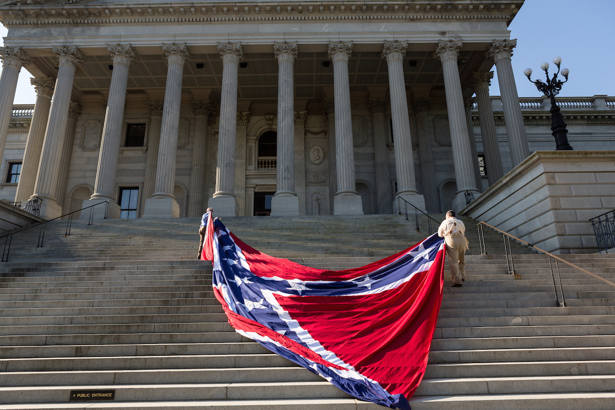 Confederate re-enactors position a gigantic Confederate flag on the steps of the South Carolina State Capitol building on May 2, 2015 in Columbia, S.C. Confederate Memorial Day is a official state holiday in South Carolina and honors those that served during the Civil War. (Richard Ellis—Getty Images)