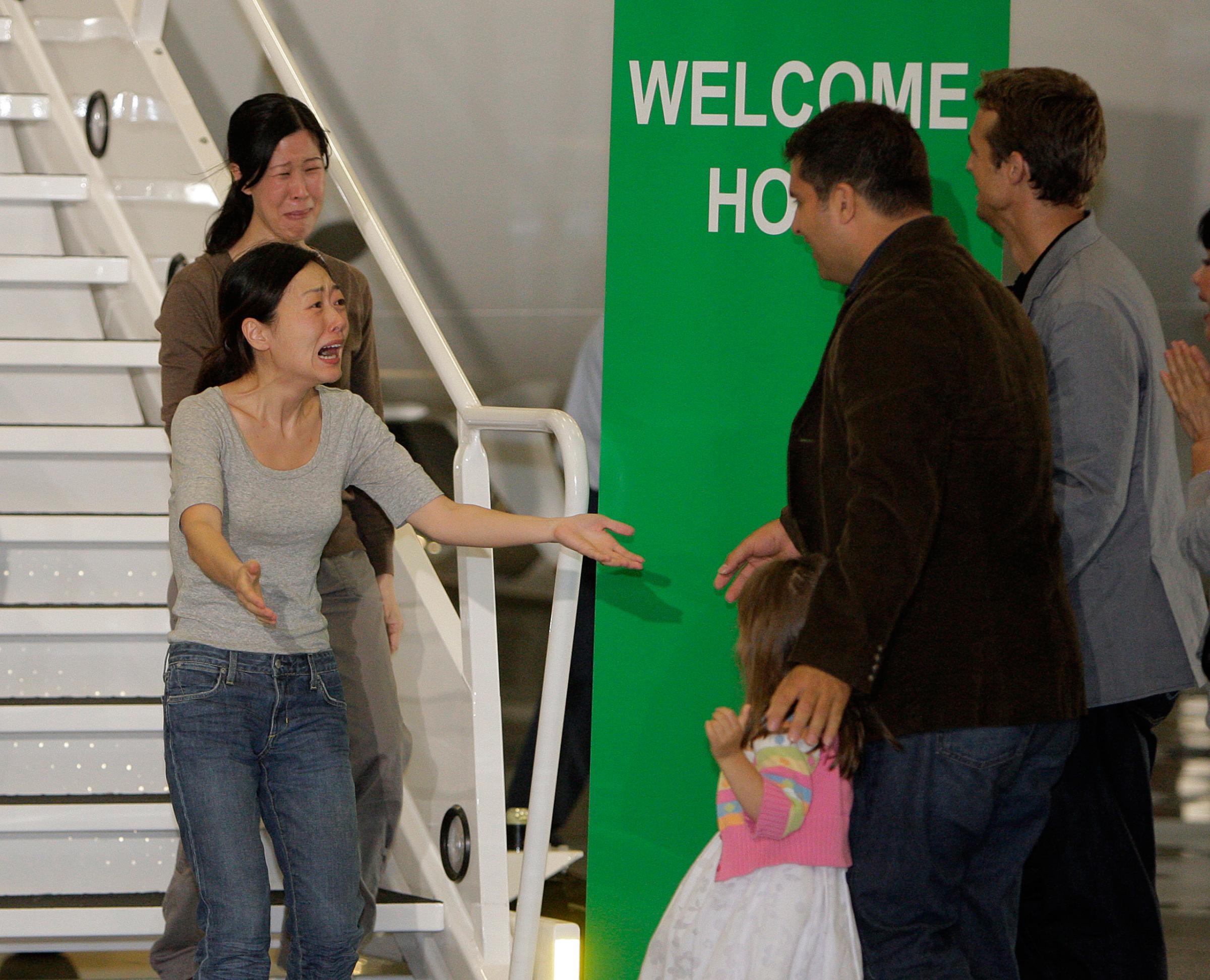 Euna Lee, left, and Laura Ling, are greeted by their husbands after their arrival at Bob Hope Airport in Burbank, Calif., on Aug. 5, 2009. The two American journalists had been arrested that March after allegedly crossing into North Korea from China.