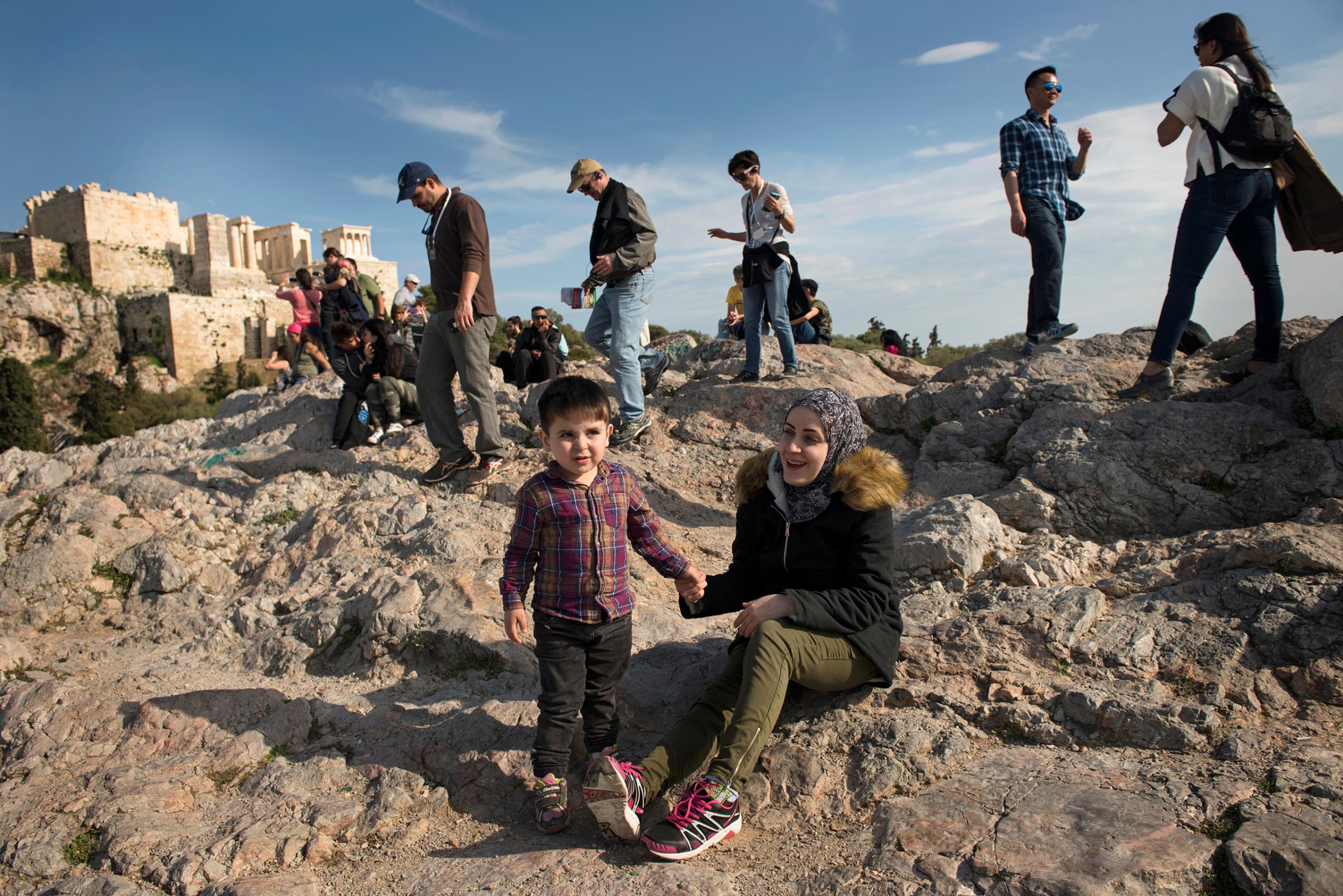 Syrian refugees Taima and her 3 year old son, Wael, walk around the Acropolis in Athens, Greece, March 30, 2017.