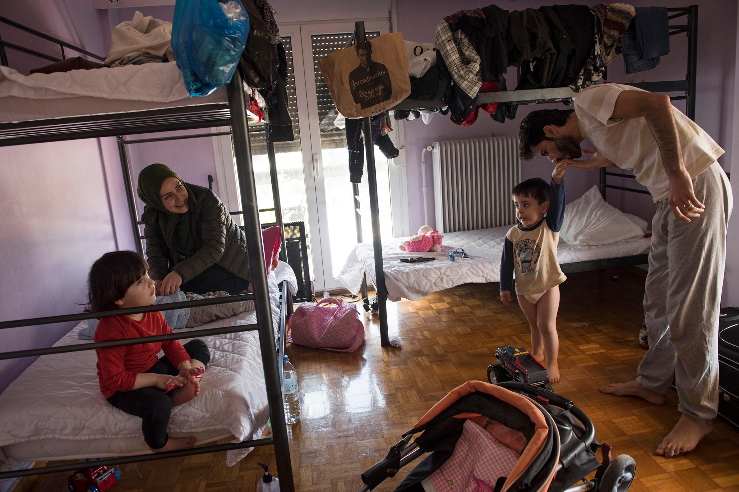 Syrian refugee, Taima, prepares to take her 6 month old daughter, Heln, for a visit to the Acropolis, while her husband, Muhannad Abzali, 28, jokes around with their other child, Wael, 3, at the temporary apartment they are staying at in Athens, Greece, March 31, 2017.