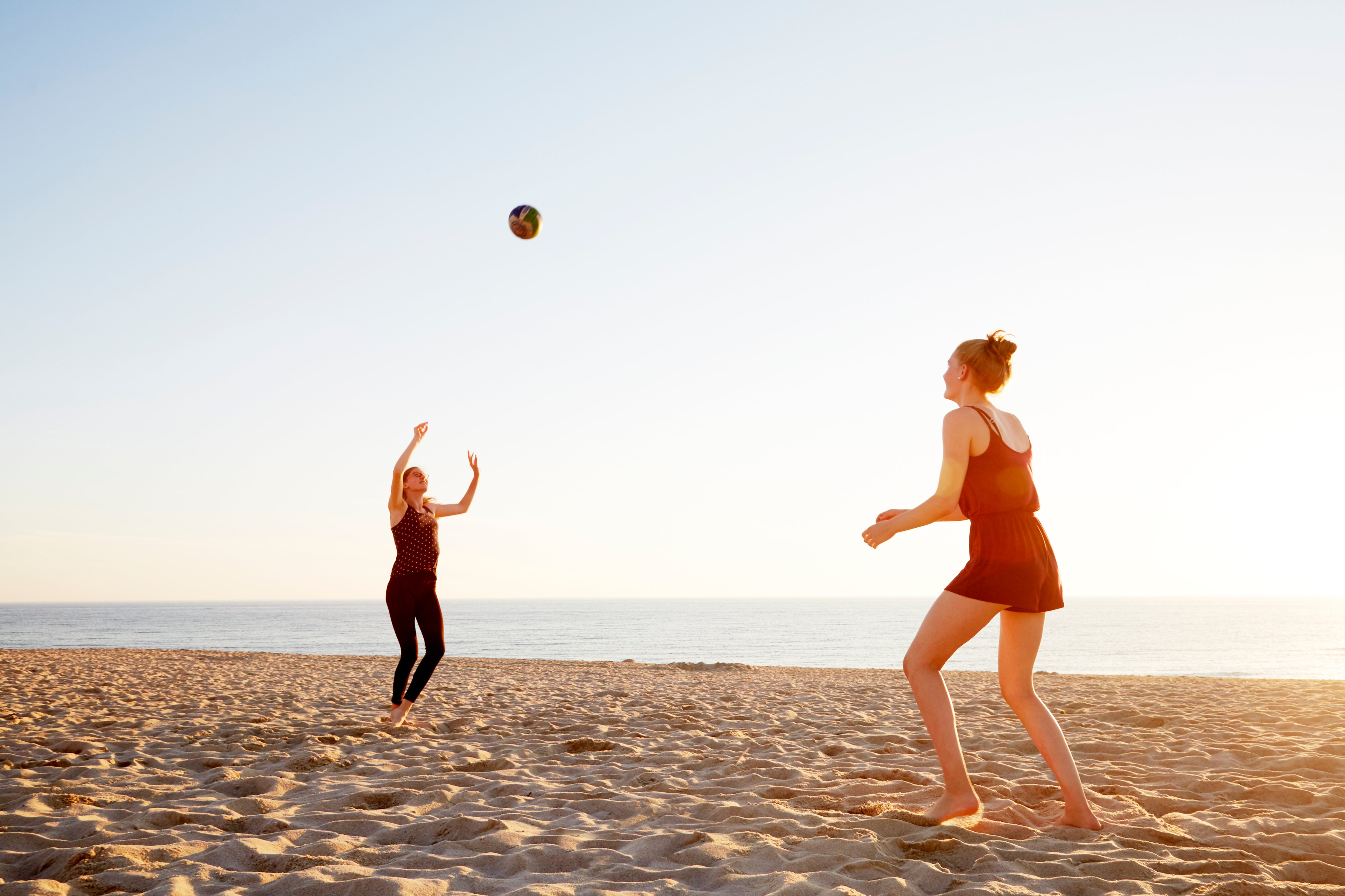 Women playing volleyball at the beach