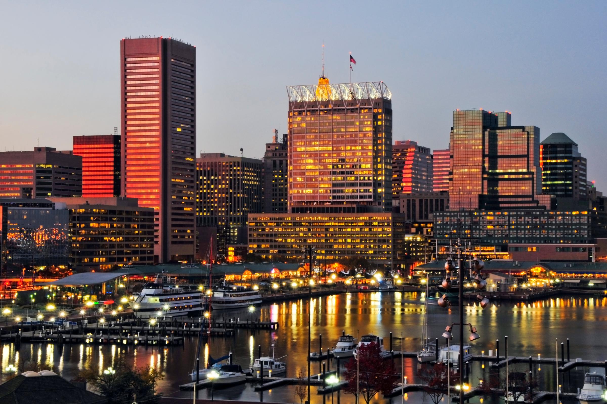 The sunset reflects off the windows of the Baltimore city skyline at dusk, Maryland.