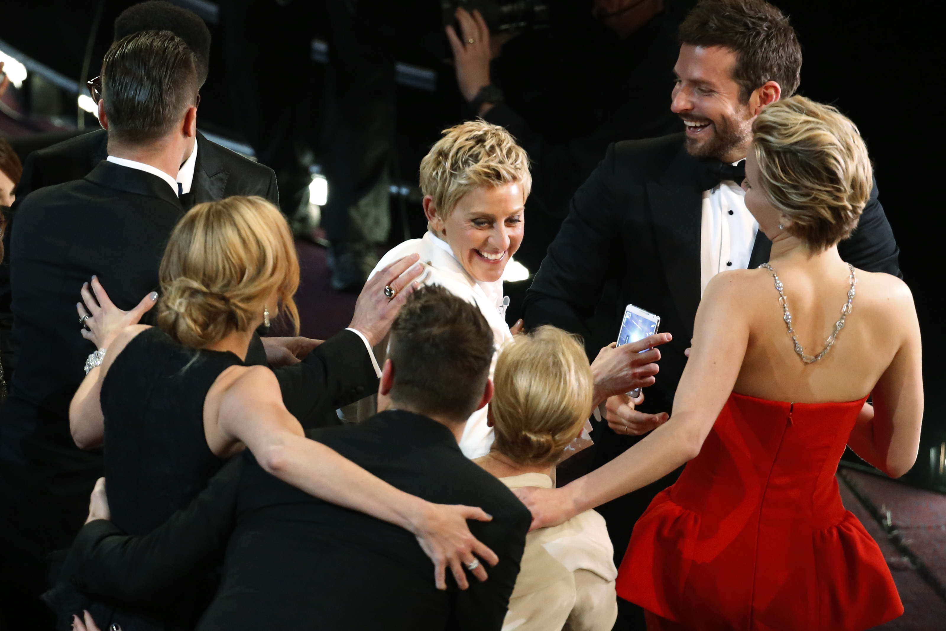 Host Ellen DeGeneres shares a laugh with Oscar nominees after taking a group 