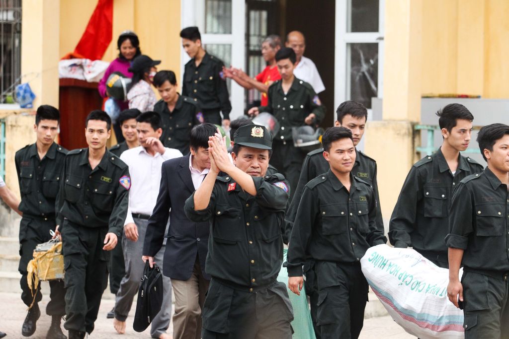 Released policemen walk out from the communal house at Dong Tam commune, My Duc district in Hanoi on April 22, 2017. (STR/AFP/Getty Images)