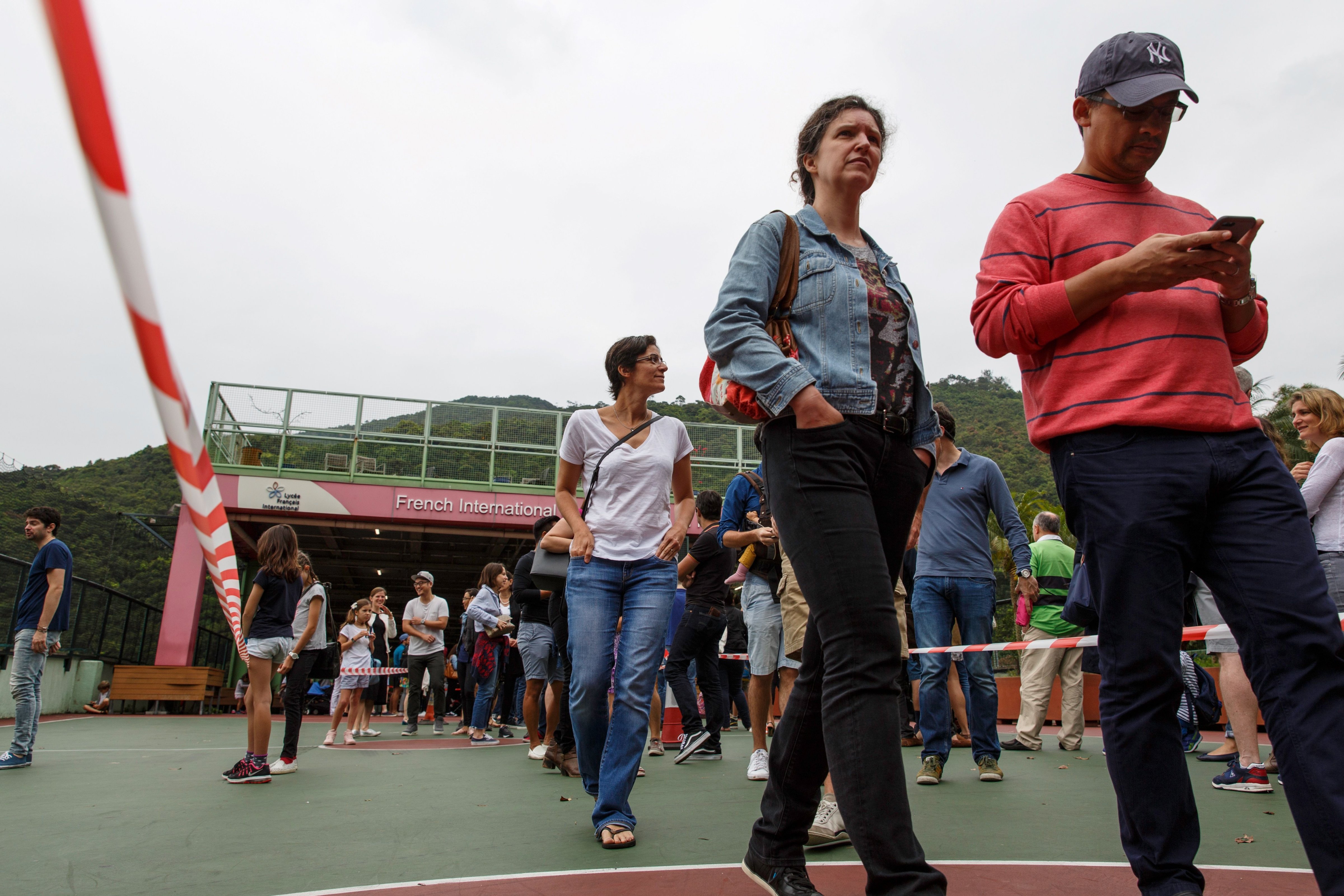 French nationals residing in Hong Kong wait in line to vote in the first round of France's presidential election at the French International School in Hong Kong, April 23, 2017. (Tengku Bahar—AFP/Getty Images)