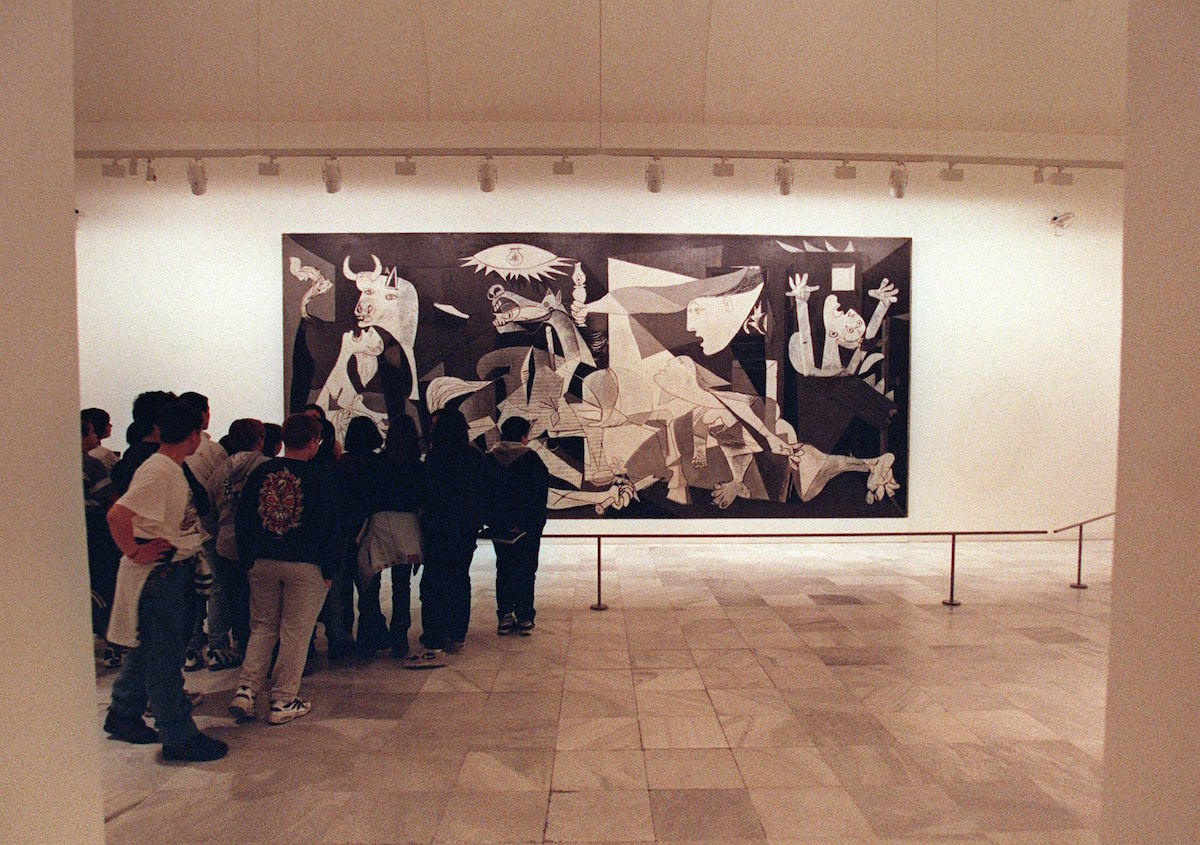 Students look at the famous Picasso painting 'Guernica' at the Queen Sofia museum in Madrid on April 23, 1997. (Dominique Faget—AFP/Getty Images)