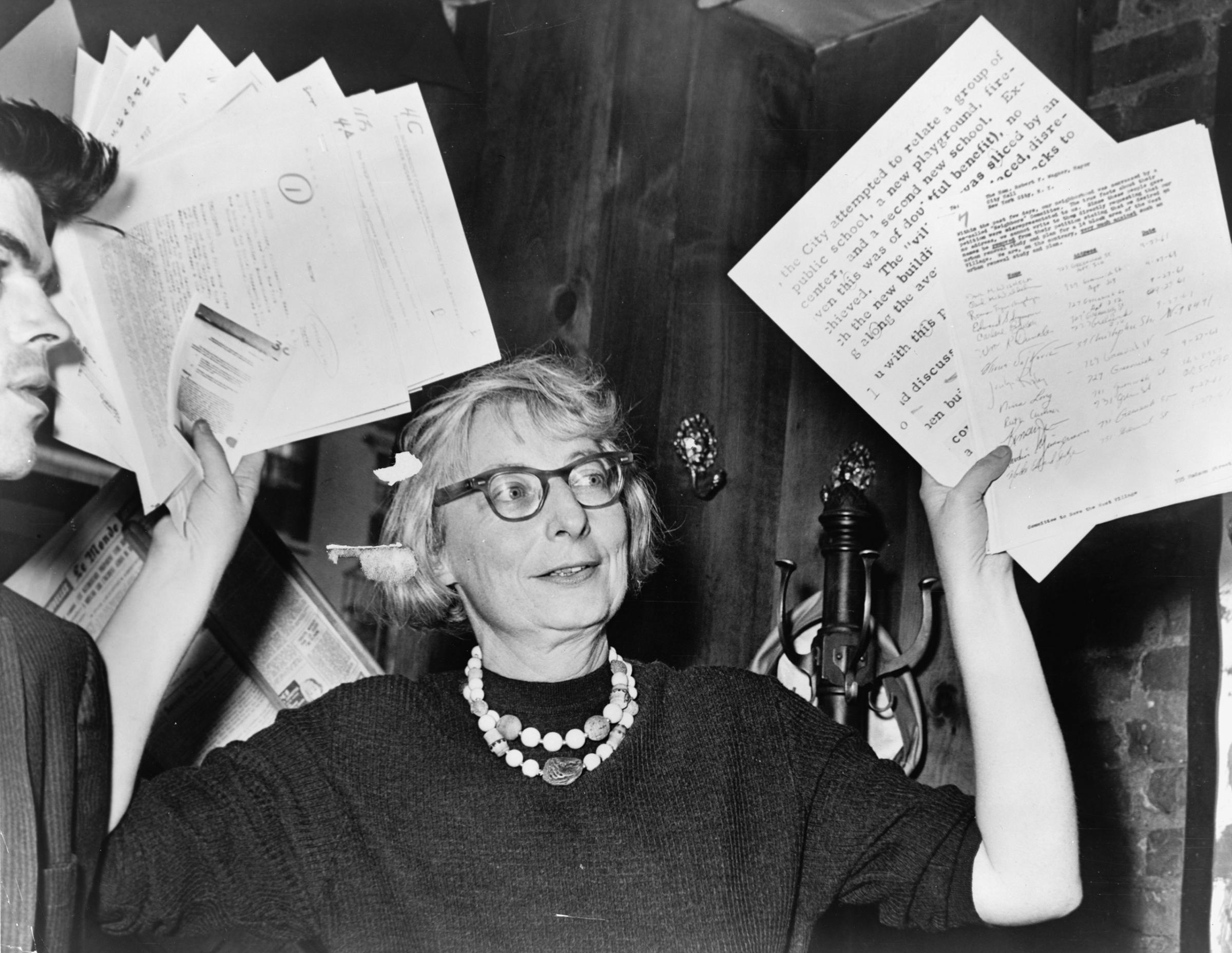 Mrs. Jane Jacobs, chairman of the Comm. to save the West Village holds up documentary evidence at press conference at Lions Head Restaurant at Hudson & Charles Sts