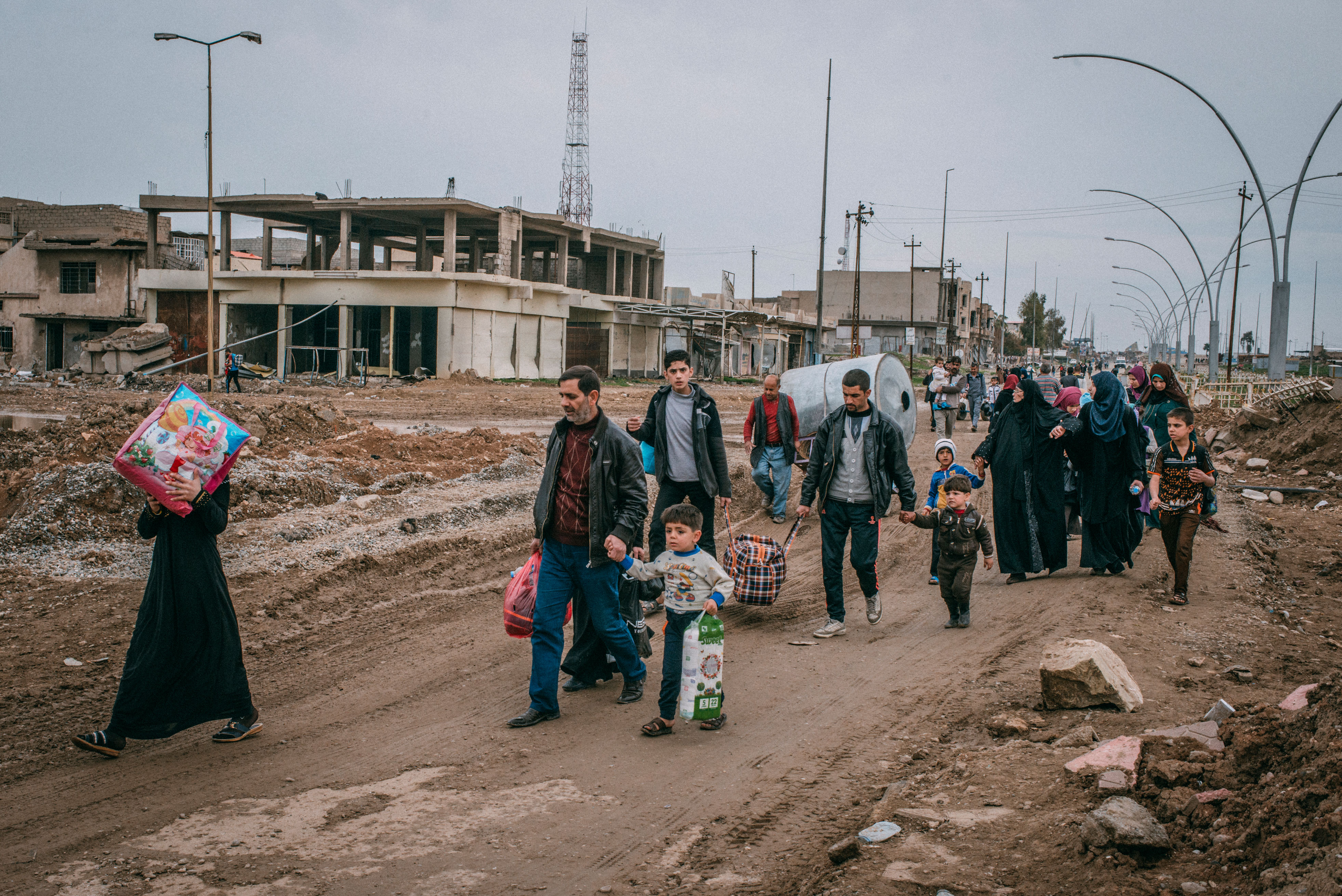 Civilians walk in Baghdad road to go back to their homes after their neighborhood has been liberated, in southwest Mosul. (Emanuele Satolli for TIME)