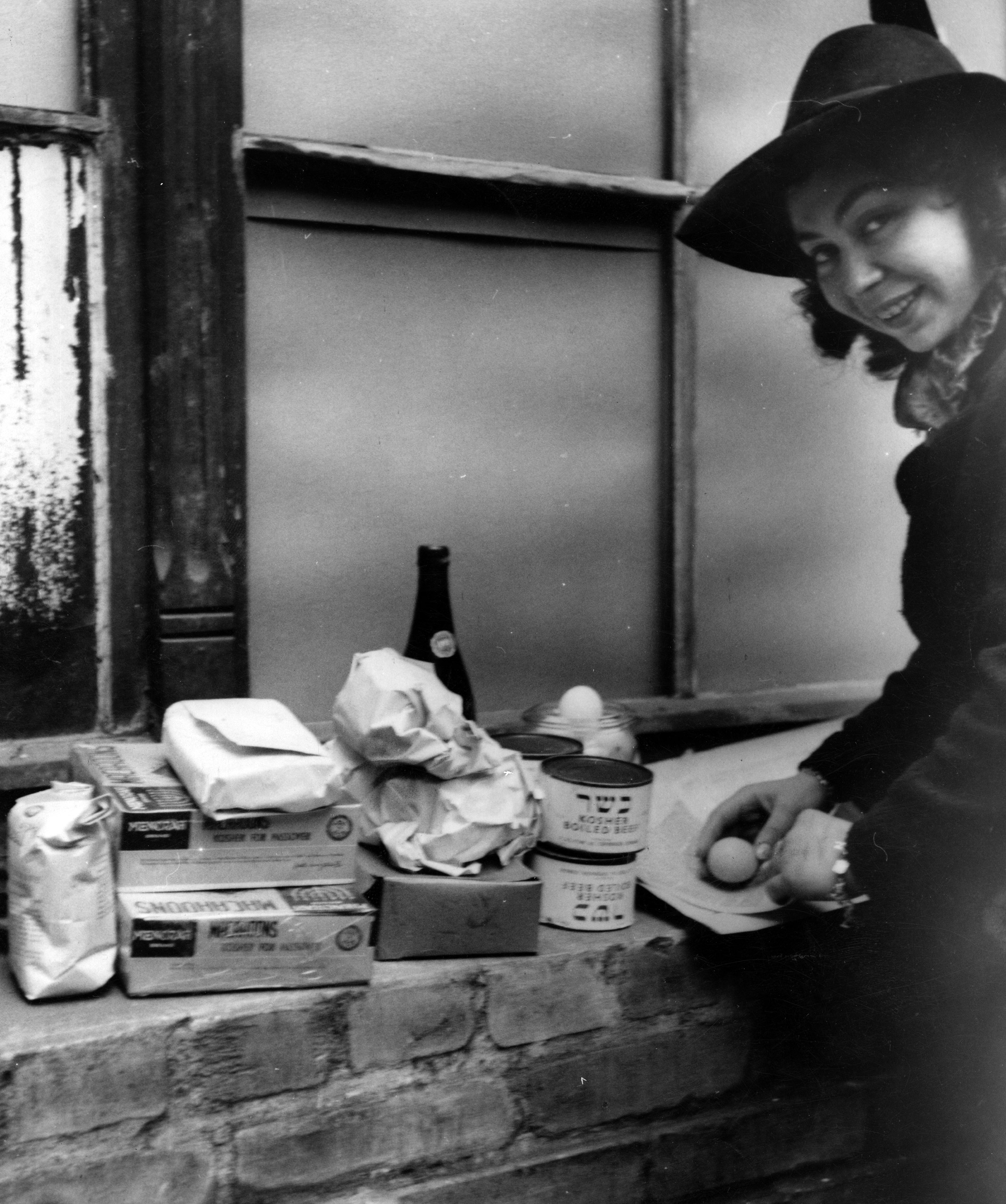 Woman with provisions supplied by JDC as part of Passover distribution. In an effort to give meaning to the first Passover spent in freedom after a decade under Nazi terror, JDC supplied over 2 million pounds of Passover supplies. Berlin, Germany, c. 1946. Photographer: Fritz Eschen, Eschen-Studio.