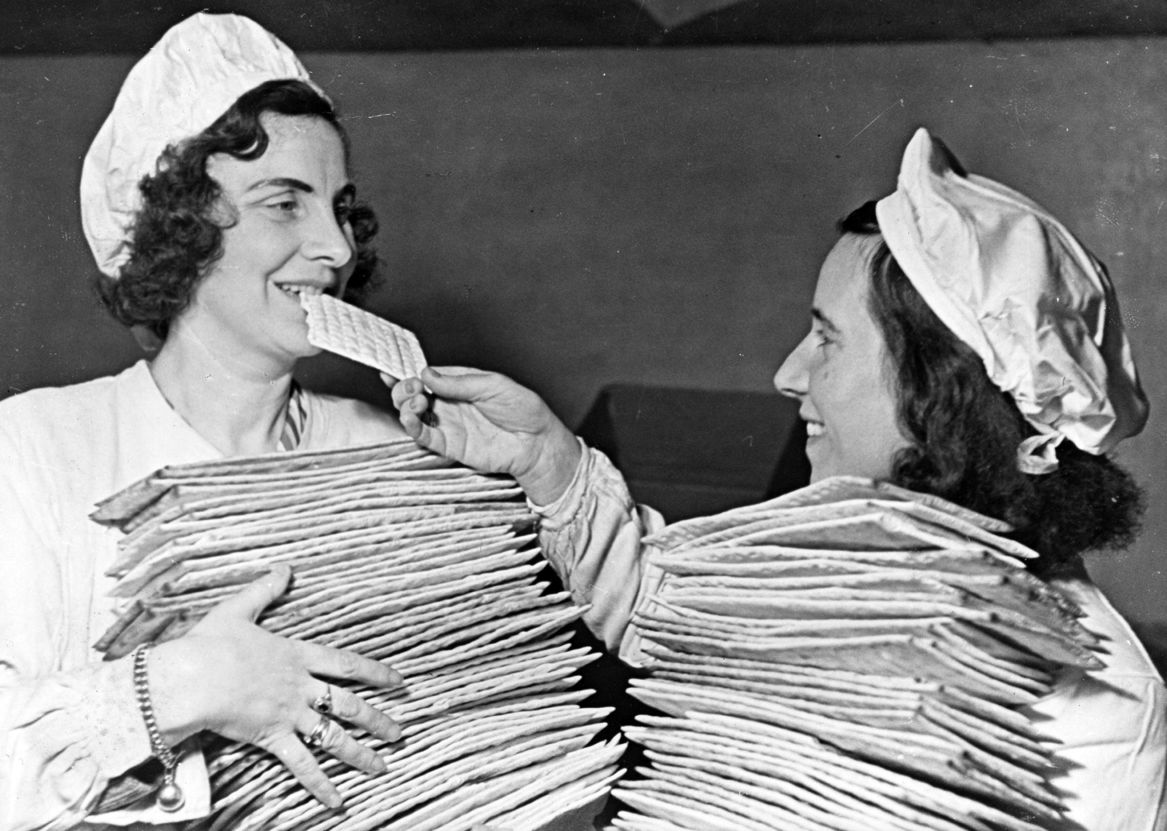 Two young women in the Sarotti Fabrik Bakery, where a goal of 85,000 pounds of matzah for Passover was set after a 10 year closure by official edict. Berlin, Germany, 1946. Photographer unknown.