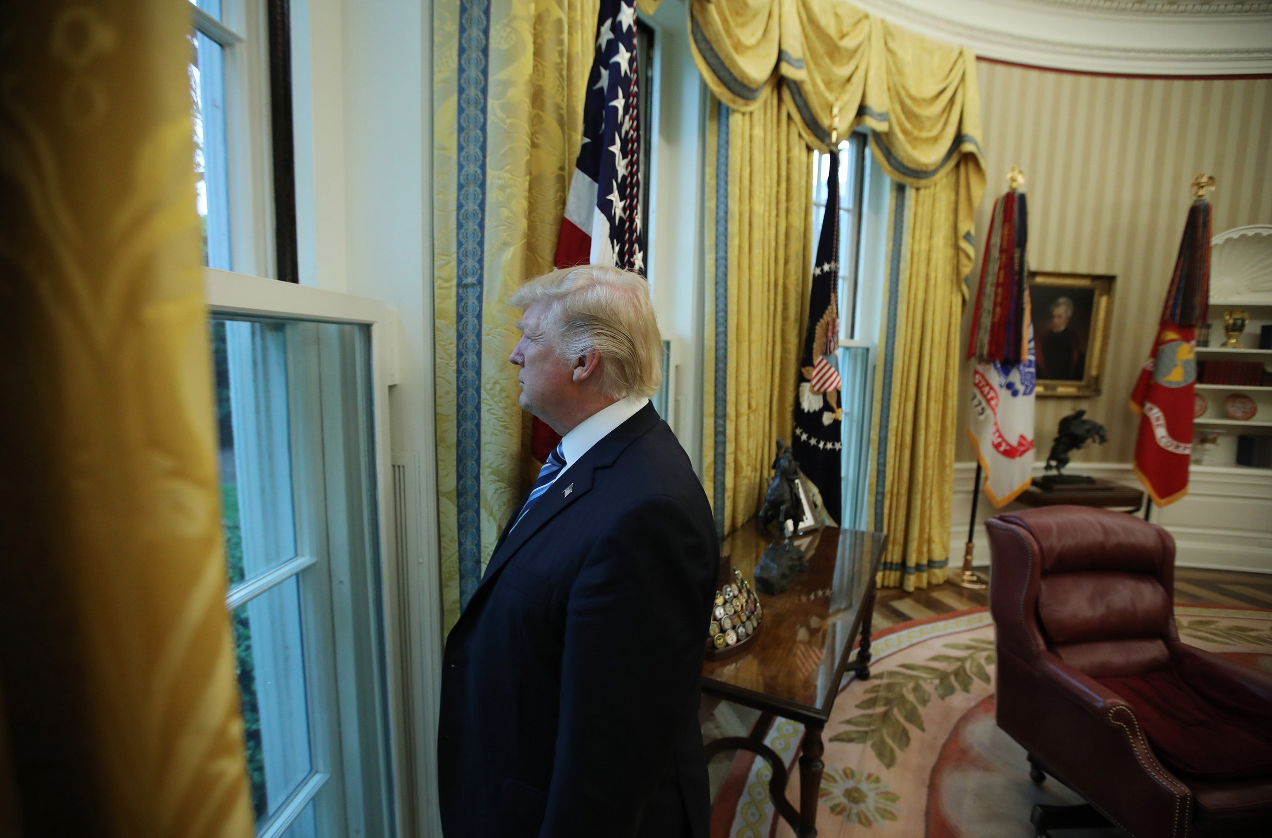 U.S. President Donald Trump looks out window of the Oval Office following an interview with Reuters at the White House in Washington