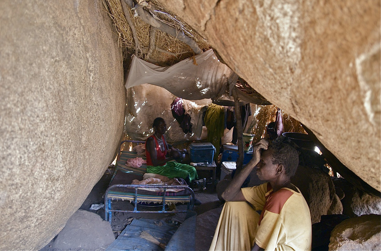 People from the Nuba Mountains in Sudan hide under boulders to escape from government bombing in April 2012. (Alan Boswell—MCT/Getty Images)