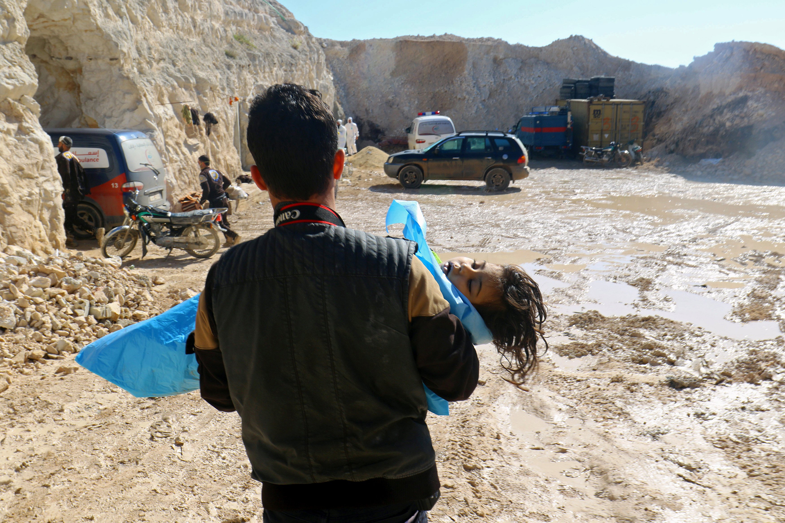 A man carries the body of a dead child, after what rescue workers described as a suspected gas attack in the town of Khan Sheikhoun, Syria, on April 4, 2017.