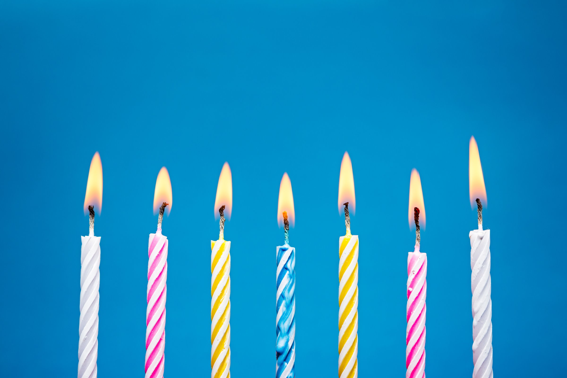 Flaming Birthday Candles on blue background TIME health stock