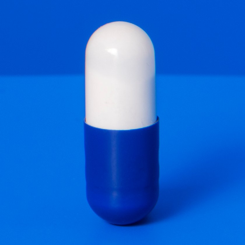 Prescription pill standing upright on blue counter TIME health