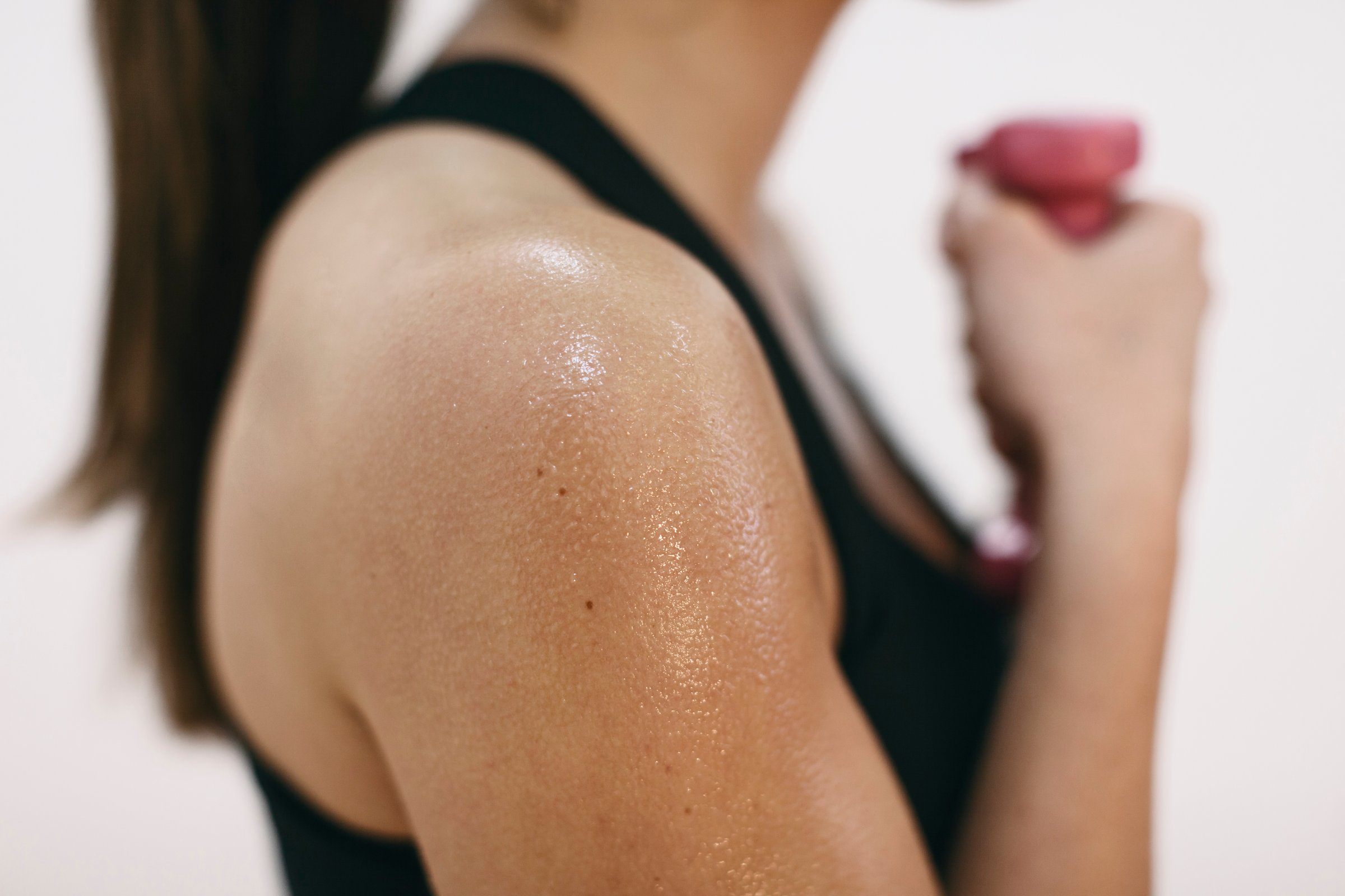 Sweaty shoulder of woman doing fitness workout TIME health stock