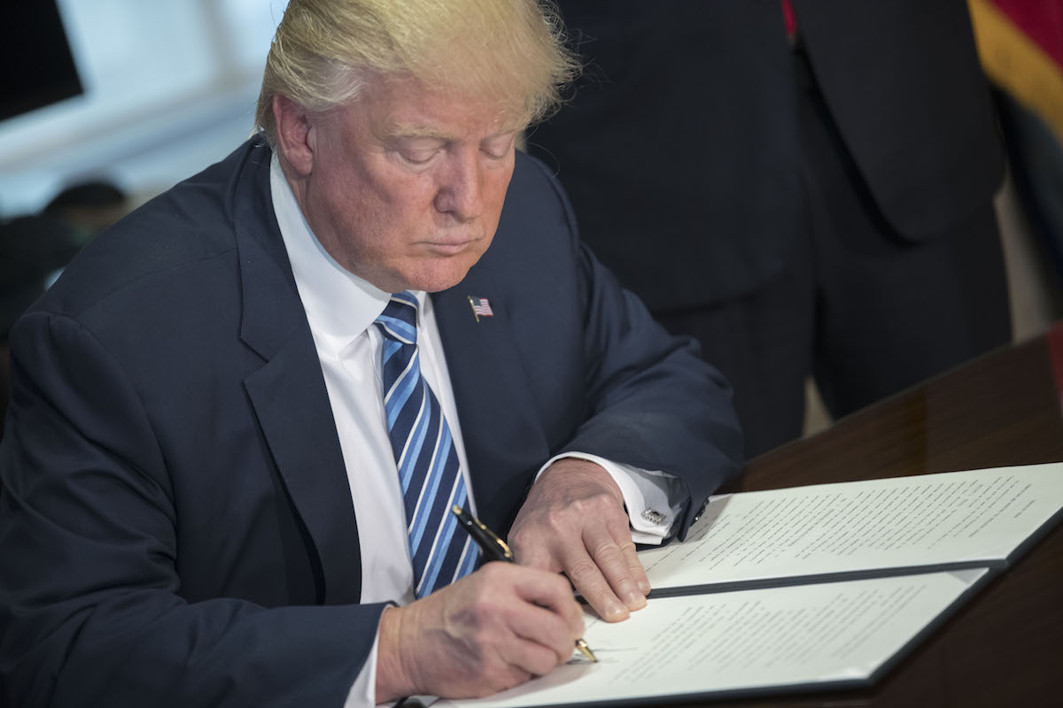 U.S. President Donald Trump signs a financial services Executive Order during a ceremony in the US Treasury Department building on April 21, 2017 in Washington, DC. (Pool / Getty Images)