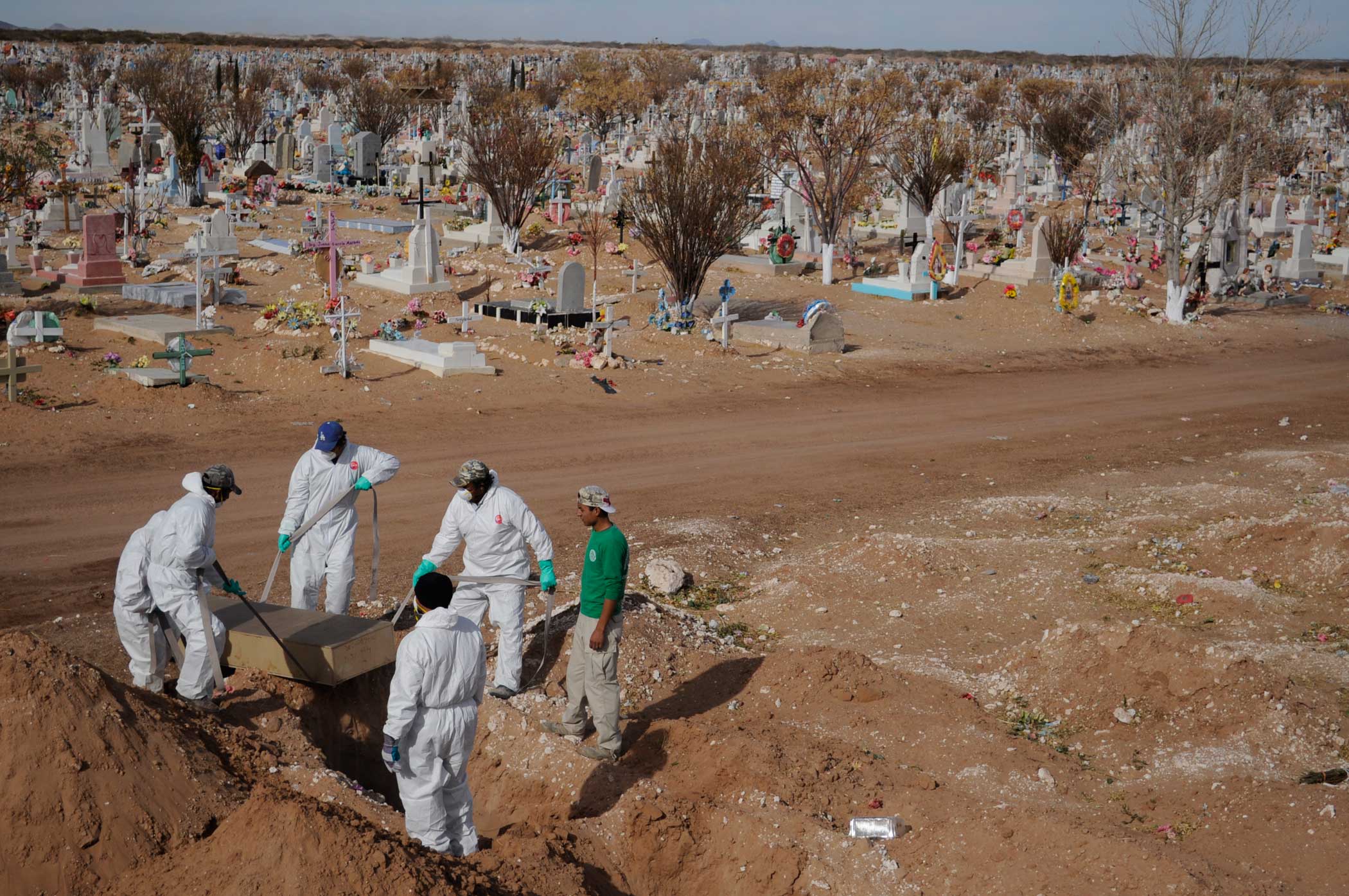 A forensics team buries an unidentified bodies in a mass grave.