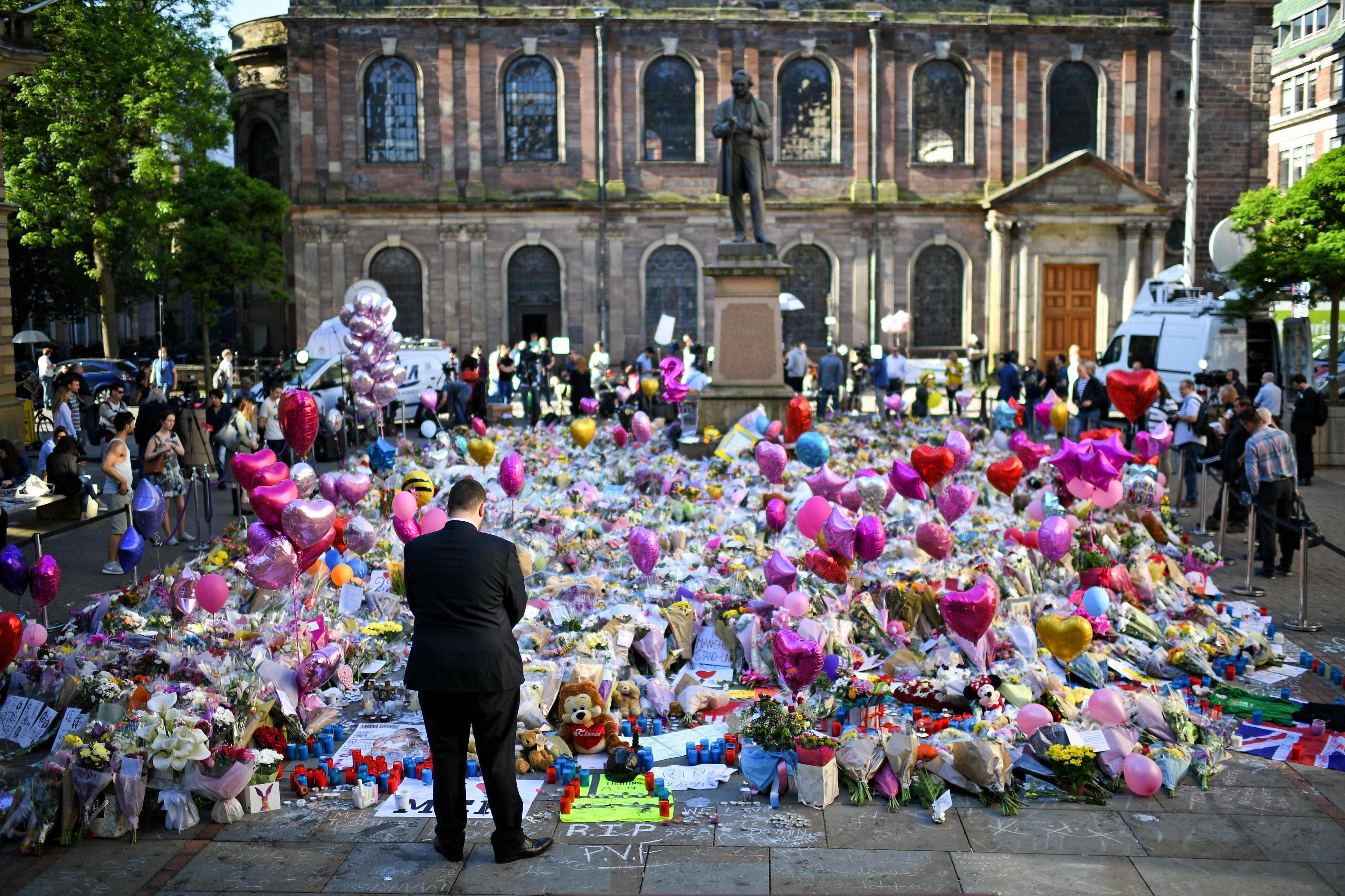 Members of the public look at tributes left in St Ann's Square for the people who died in Monday's terror attack at the Manchester Arena on May 26, 2017 in Manchester, England. (Jeff J Mitchell—Getty Images)