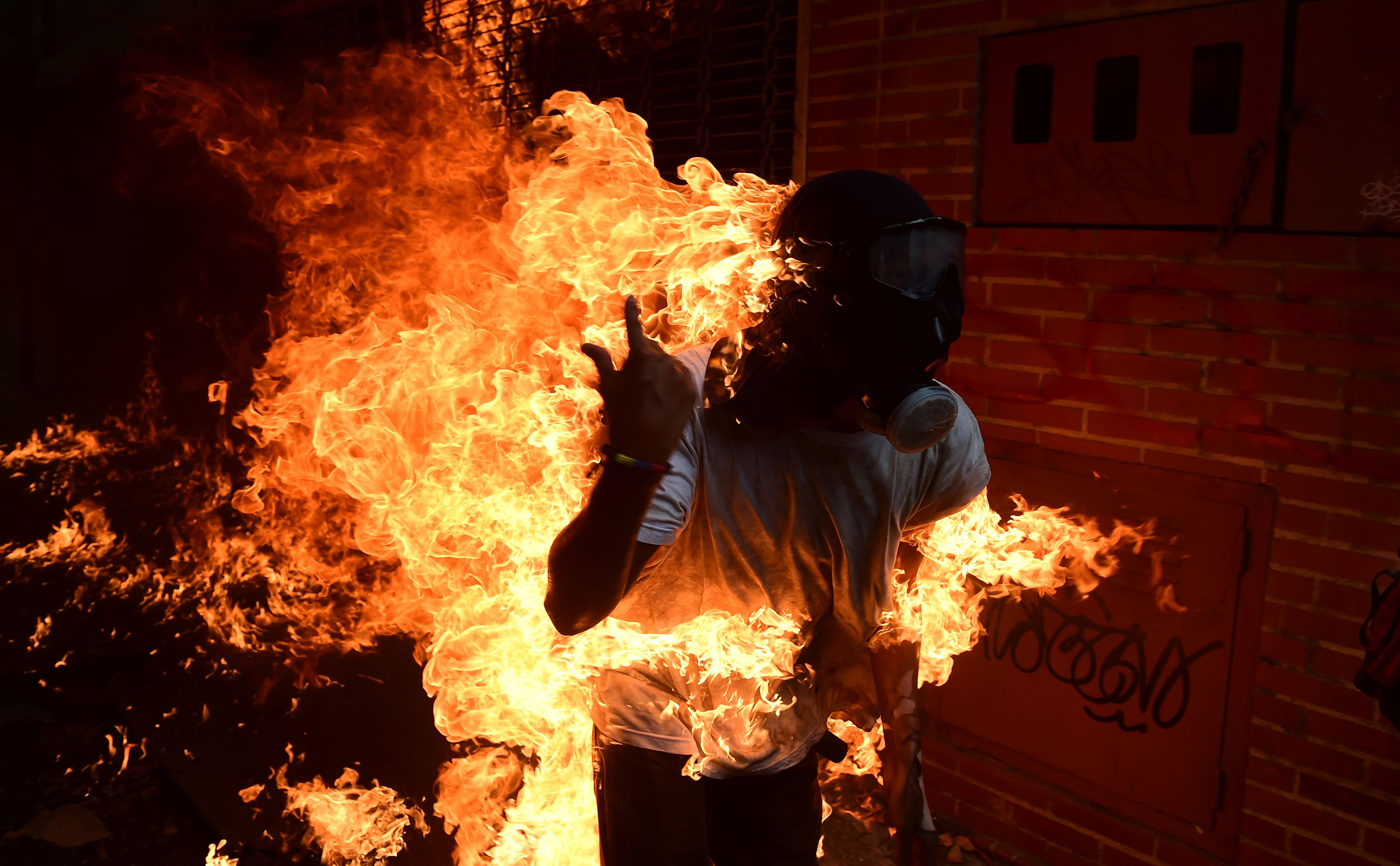 A man set ablaze runs during an anti-Maduro protest in Caracas on May 3, 2017.