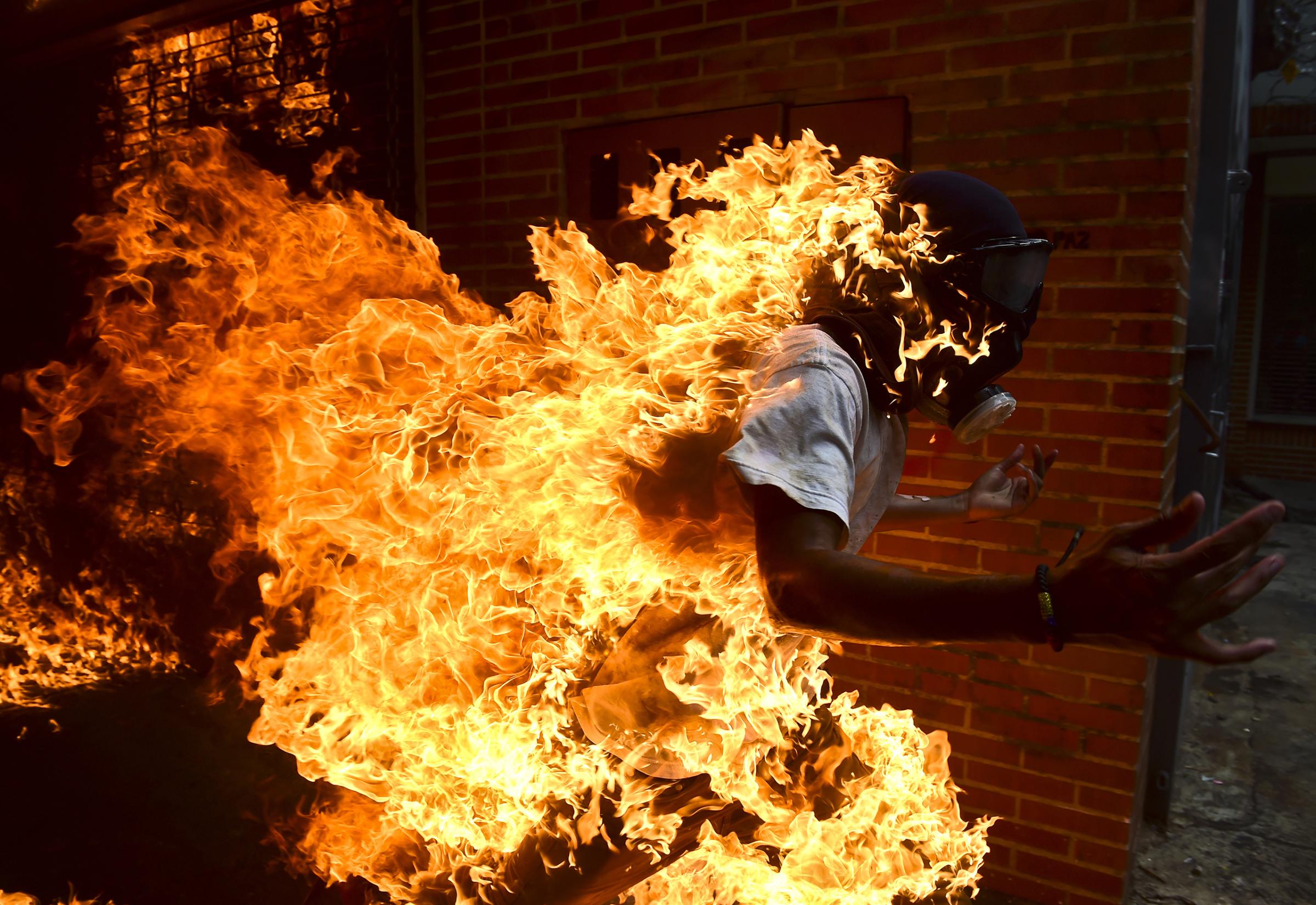 A demonstrator set ablaze runs during an anti-Maduro protest in Caracas on May 3, 2017.
