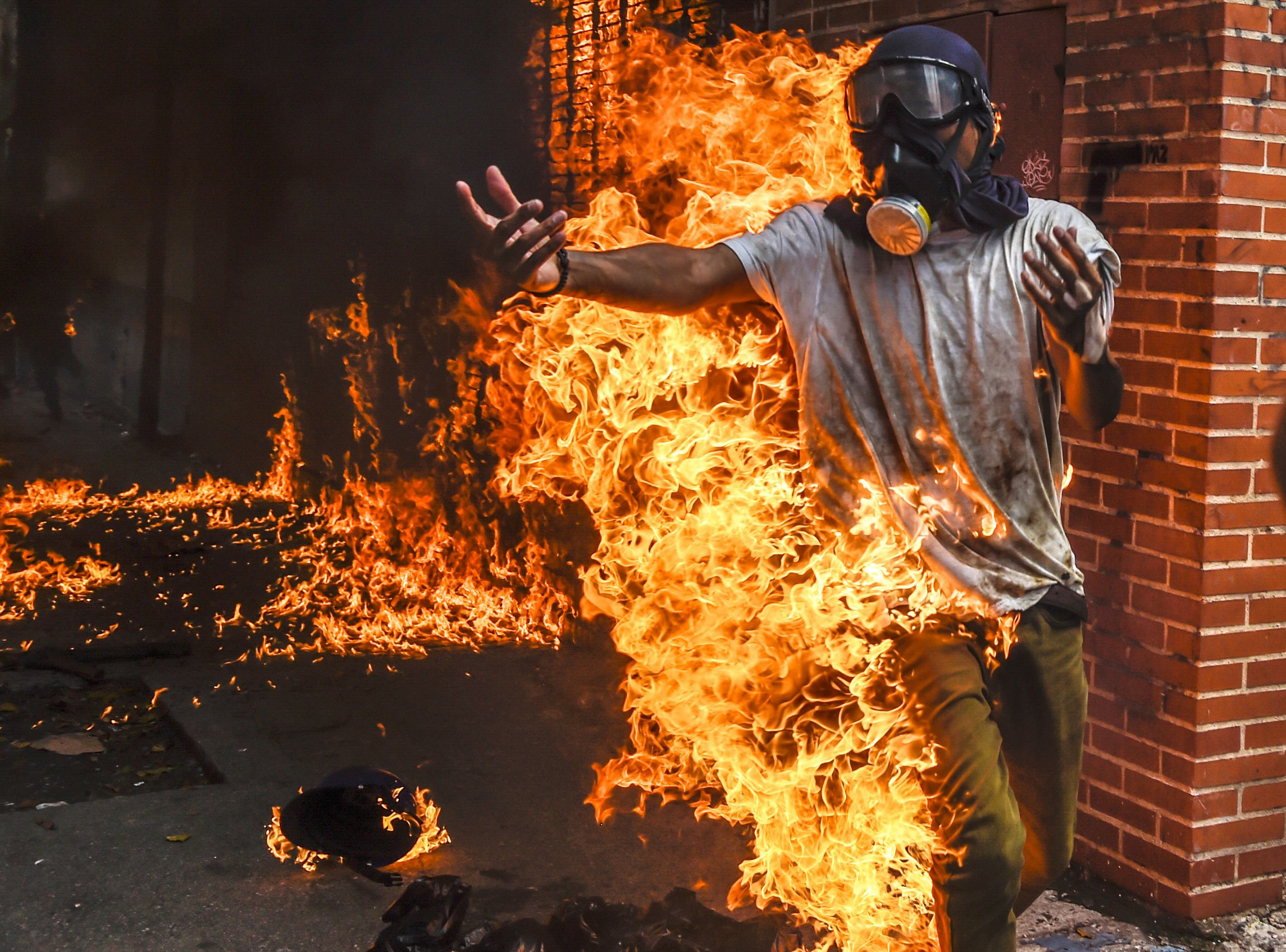 A demonstrator set ablaze runs during an anti-Maduro protest in Caracas on May 3, 2017.