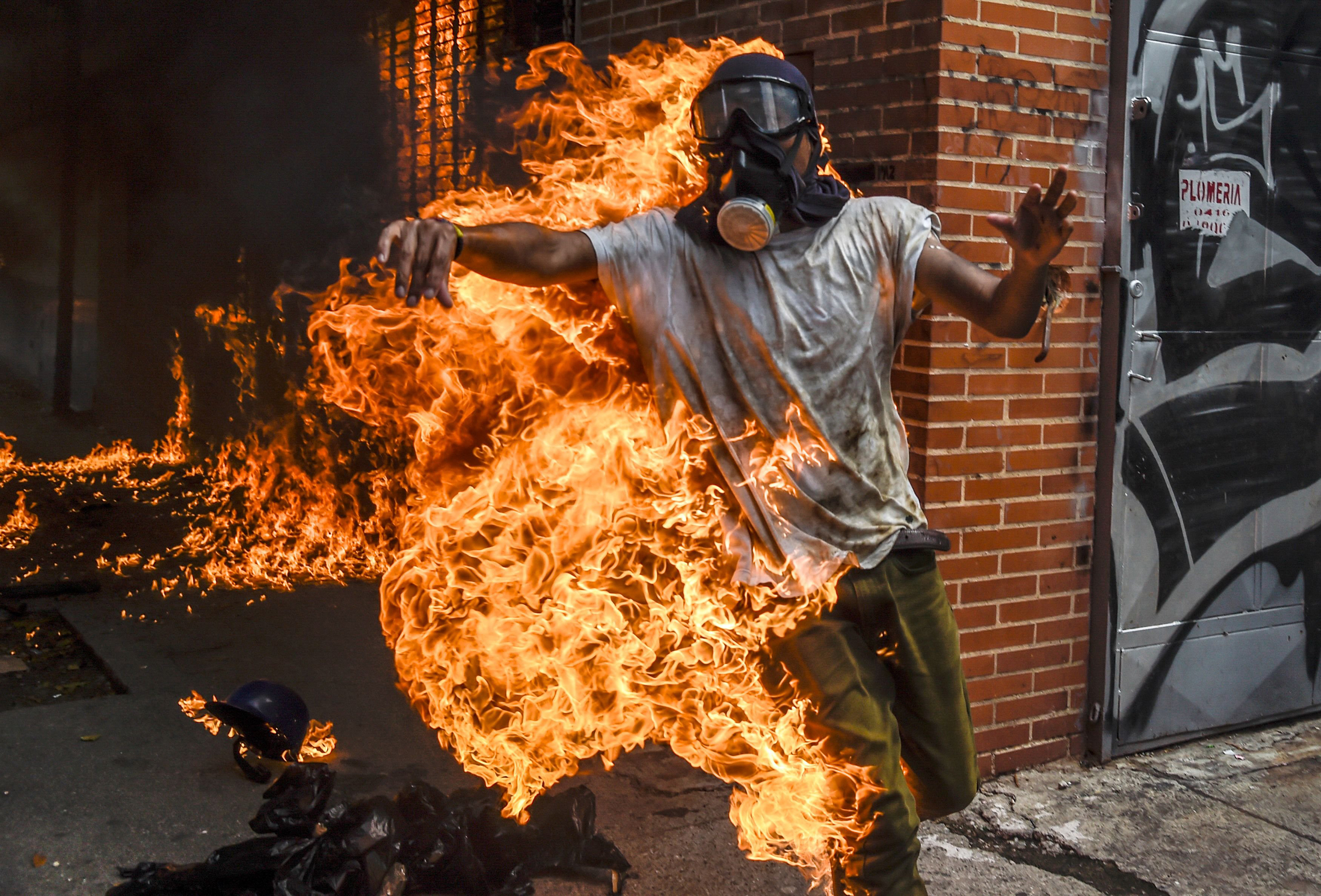 A demonstrator set ablaze during an anti-Maduro protest reaches out in Caracas on May 3, 2017.